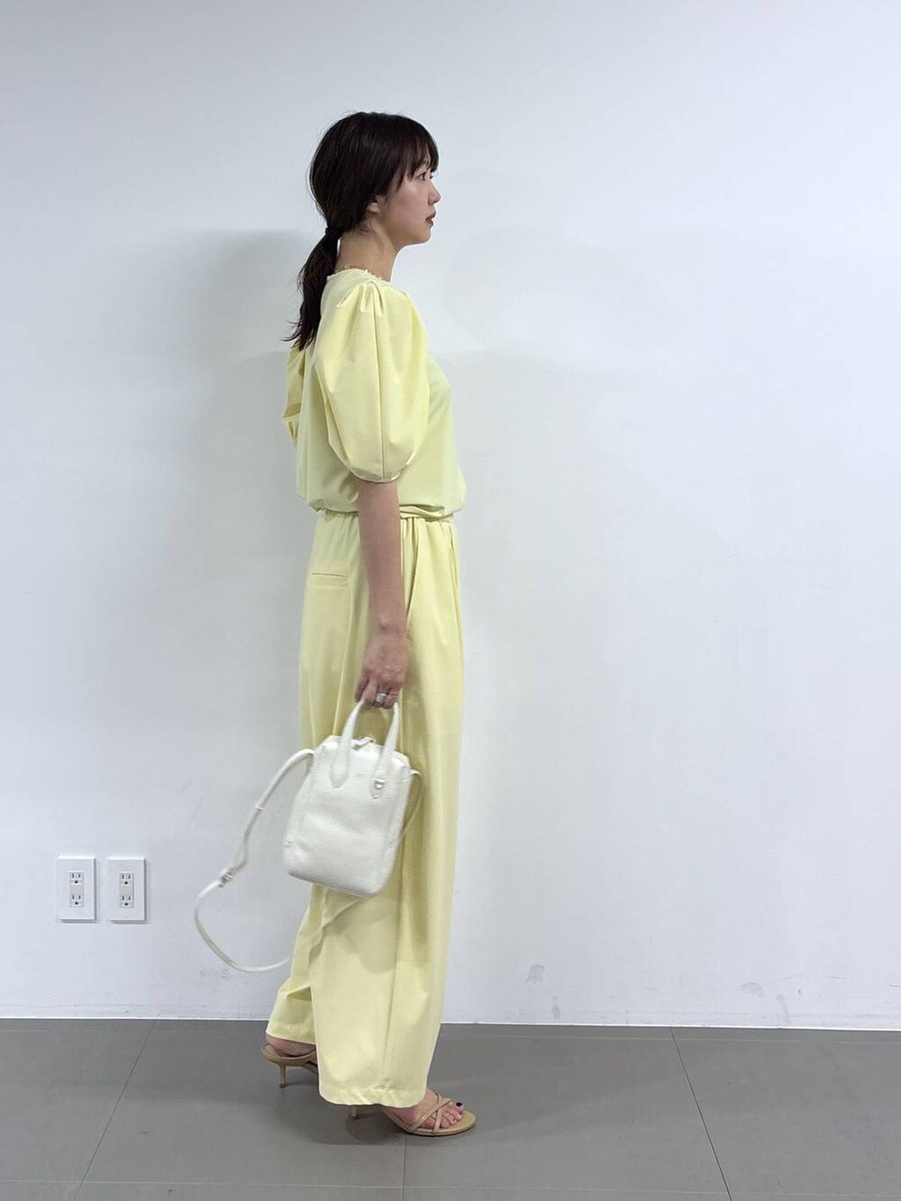 イエロー系のシャツ/ブラウス、ホワイト系のショルダーバッグ、イエロー系のその他パンツを着用したレディースの春コーディネートの3枚目の写真