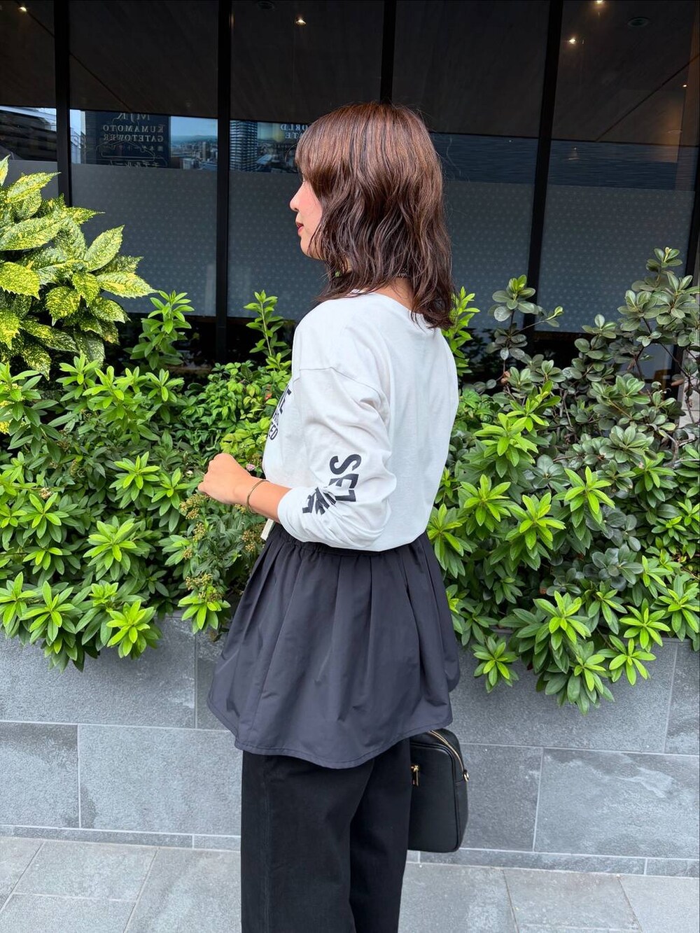 ブラック系のデニムパンツ、ブラック系のベスト、ホワイト系のTシャツ/カットソーを着用したレディースの夏コーディネートの3枚目の写真