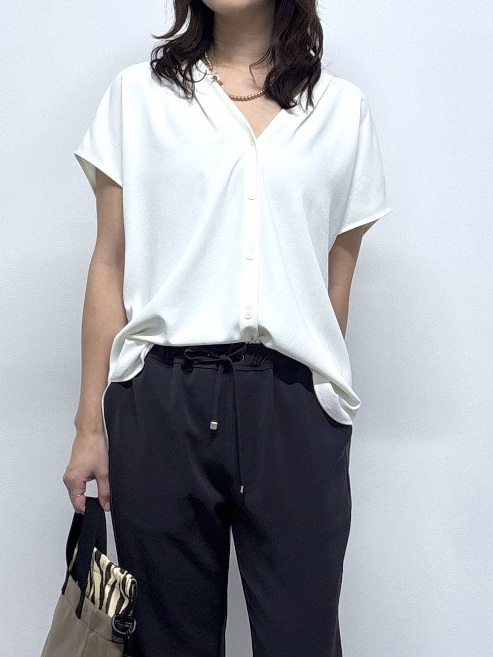 ホワイト系のシャツ/ブラウス、ブラック系のサンダル、グレー系のその他パンツを着用したレディースの春コーディネートの2枚目の写真