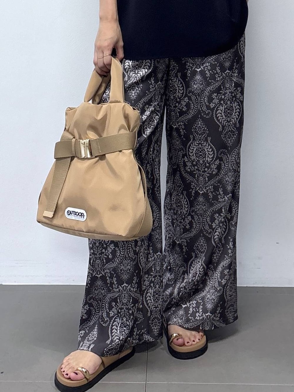 ブラウン系のショルダーバッグ、グレー系のその他パンツ、ブラウン系のサンダルを着用したレディースの春コーディネートの3枚目の写真
