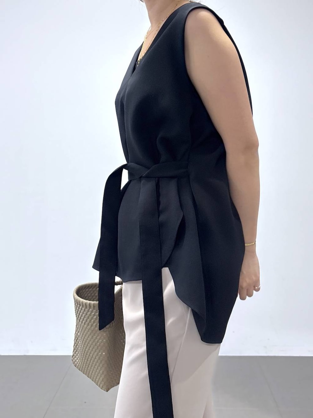 ホワイト系のパンプス、ブラック系のシャツ/ブラウス、ベージュ系のハンドバッグを着用したレディースの夏コーディネートの3枚目の写真