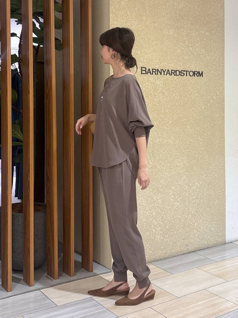 グリーン系のTシャツ/カットソー、ブラウン系のハンドバッグ、イエロー系のパンプスを着用したレディースの冬コーディネートの2枚目の写真