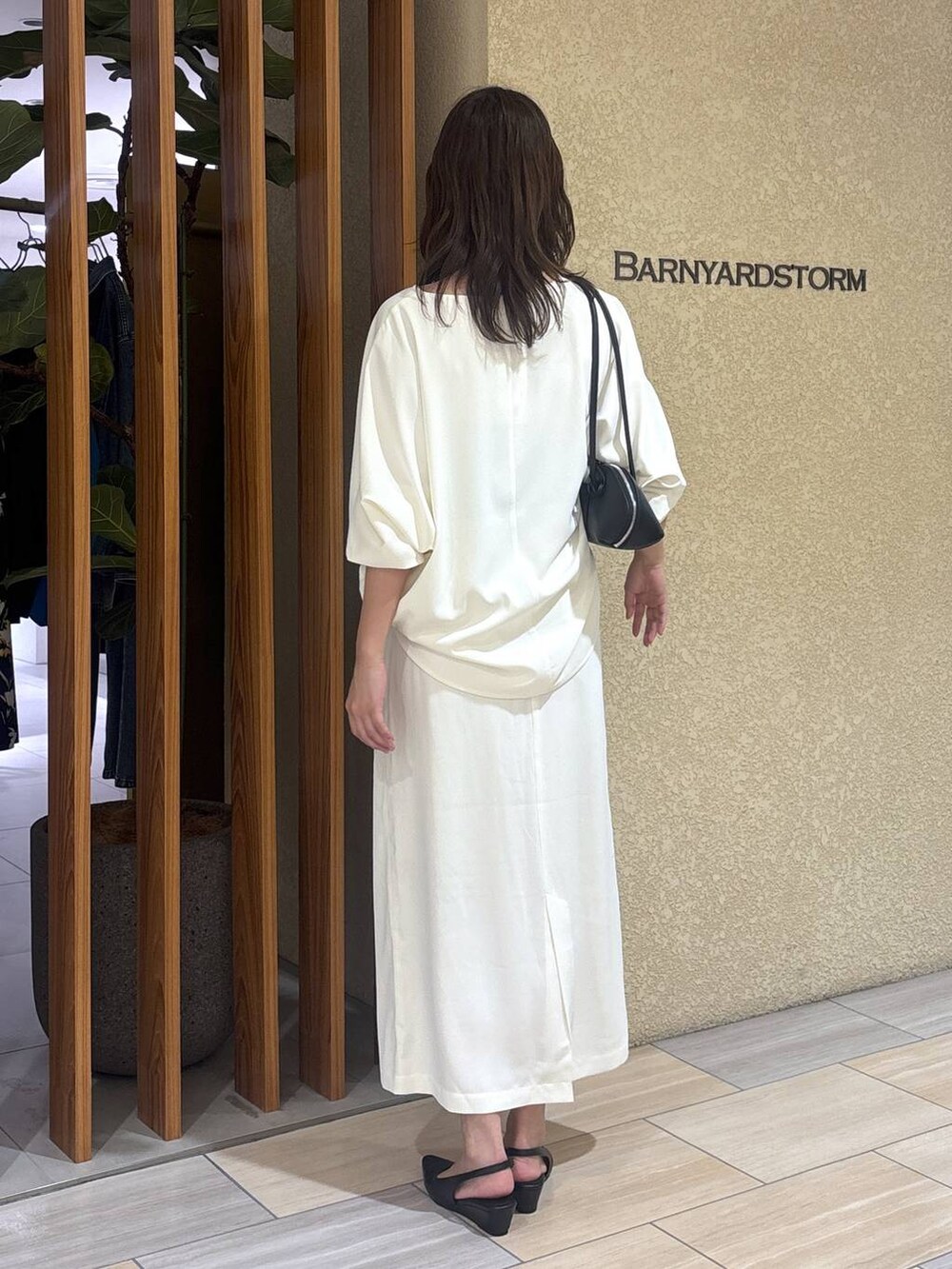 ホワイト系のスカート、ホワイト系のTシャツ/カットソー、ブラック系のハンドバッグを着用したレディースの冬コーディネートの5枚目の写真