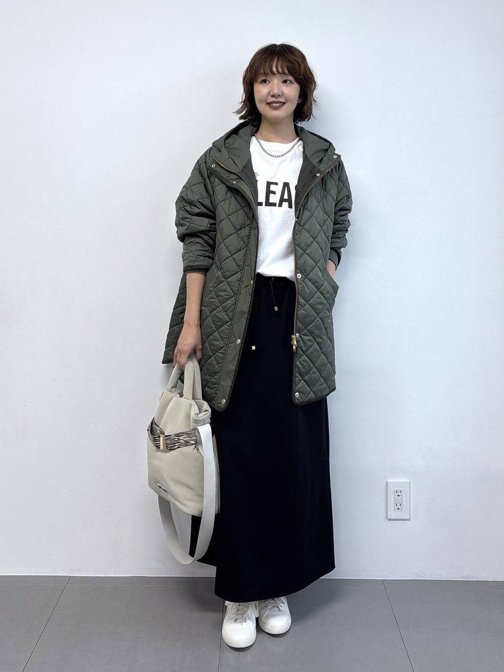 ホワイト系のTシャツ/カットソー、グレー系のトートバッグ、ブラック系のスカートを着用したレディースの秋コーディネートの3枚目の写真