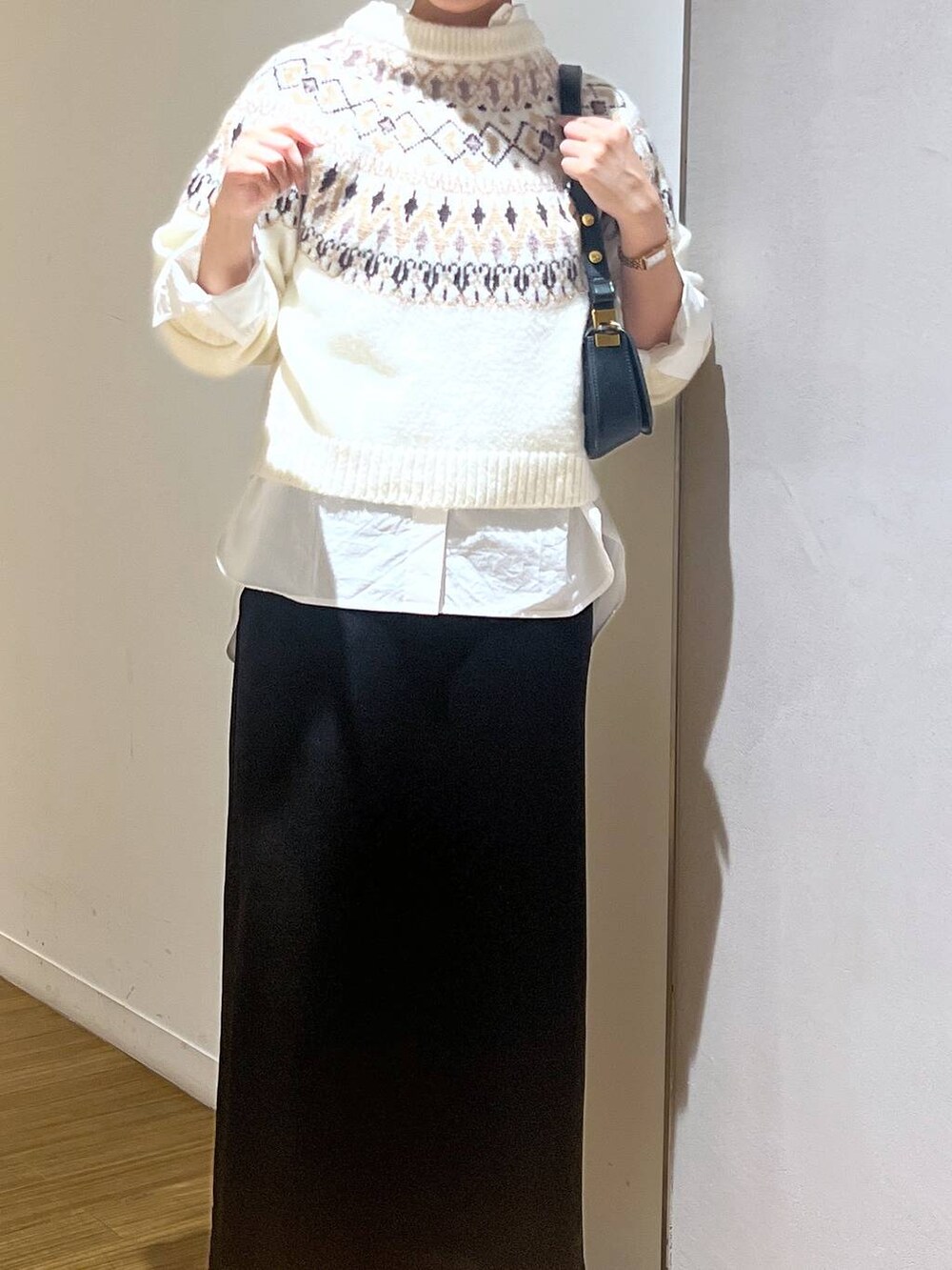 ブラック系のブーツ、ブラック系のショルダーバッグ、ホワイト系のシャツ/ブラウスを着用したレディースの秋コーディネートの2枚目の写真