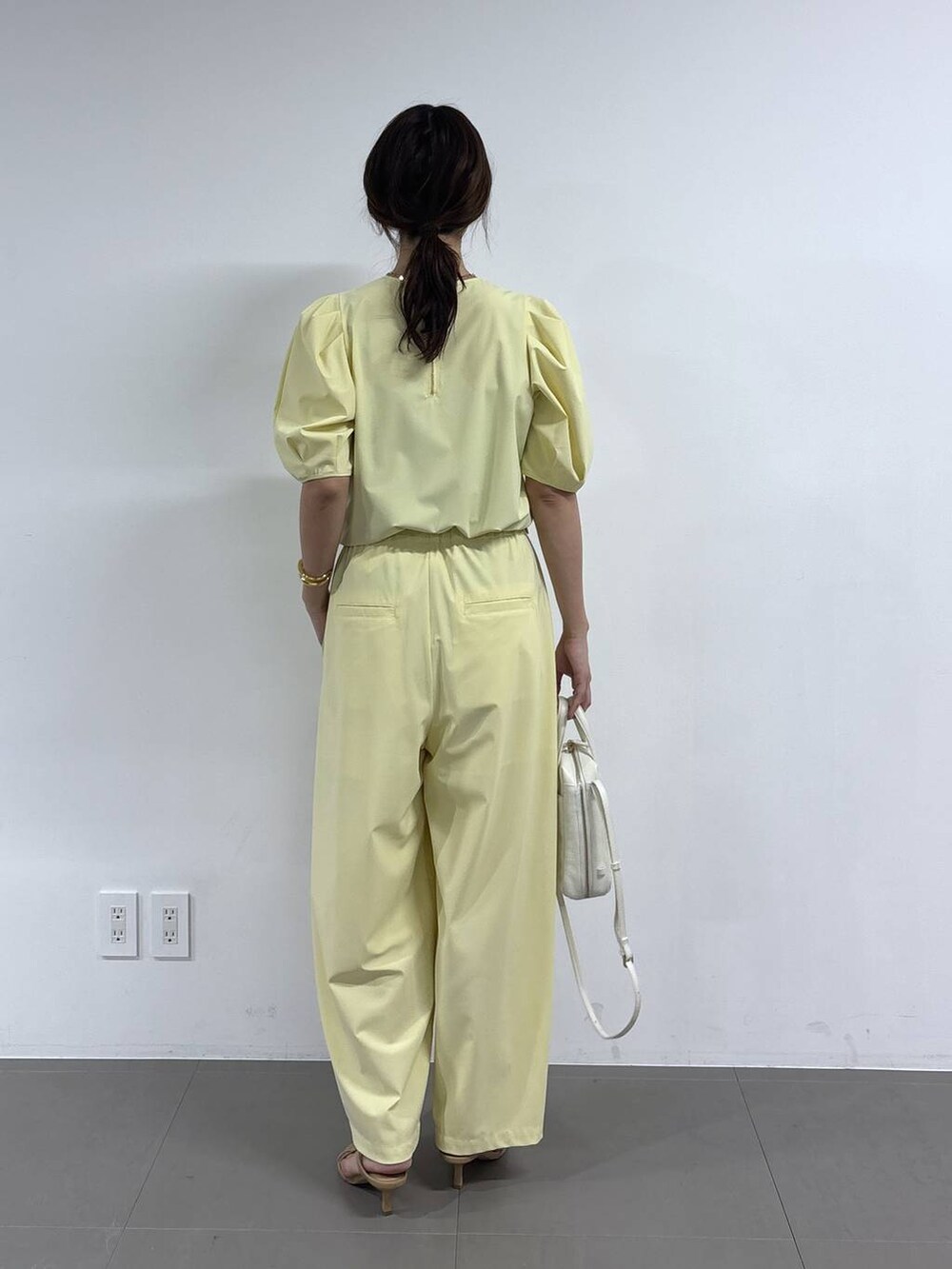 イエロー系のシャツ/ブラウス、ホワイト系のショルダーバッグ、イエロー系のその他パンツを着用したレディースの春コーディネートの2枚目の写真