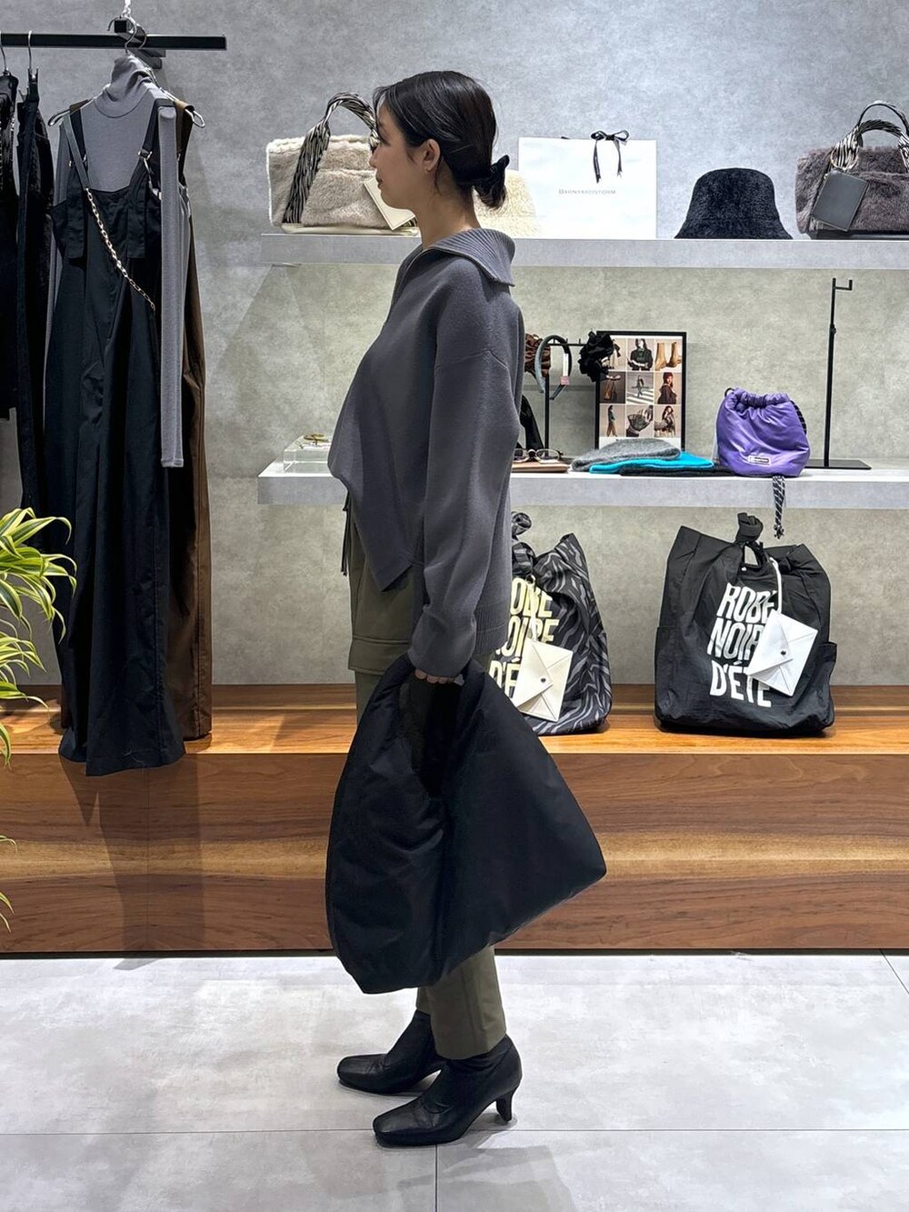 グリーン系のカーゴパンツ、ブラック系のトートバッグ、グレー系のニット/セーターを着用したレディースの冬コーディネートの3枚目の写真