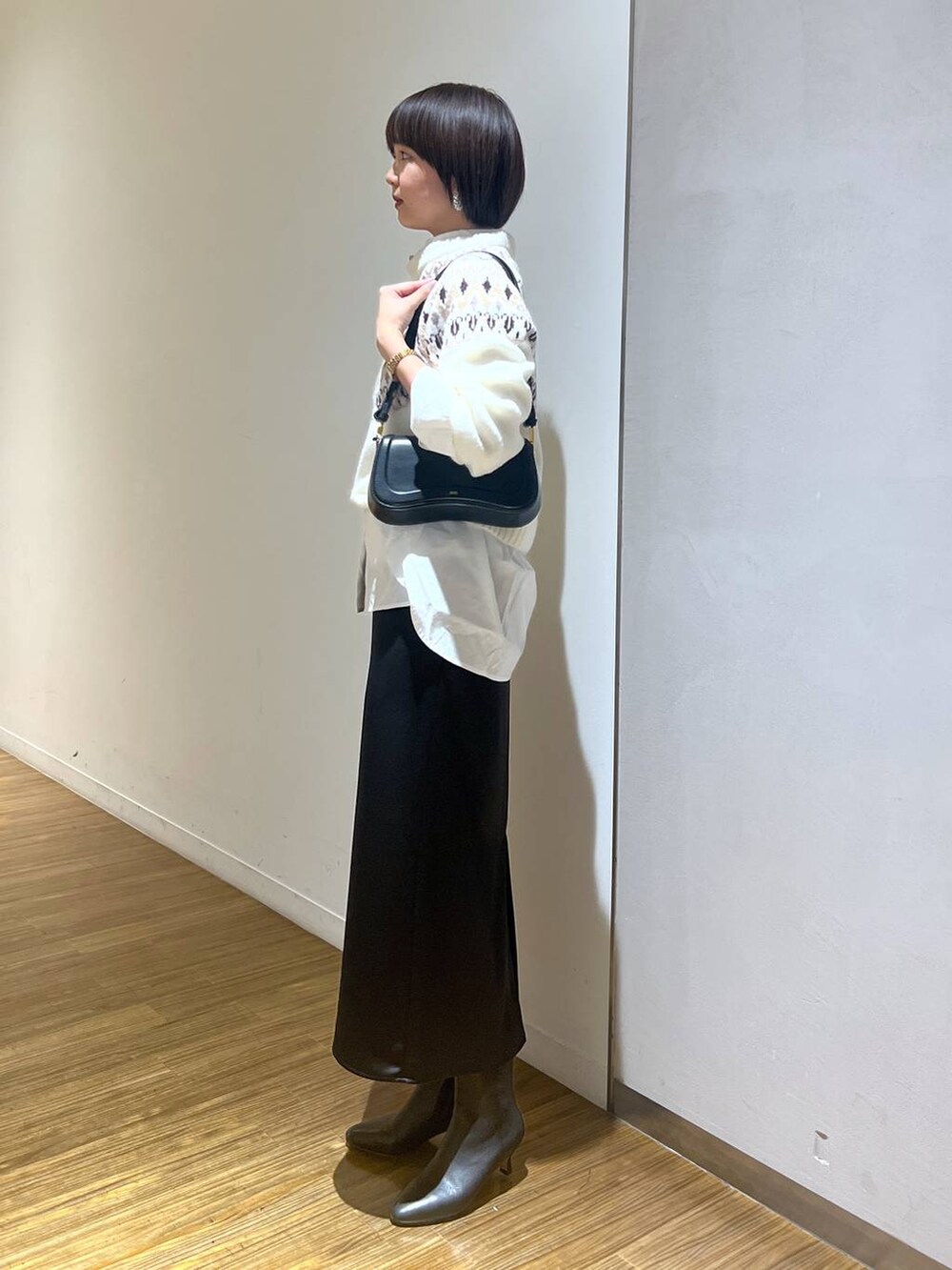 ブラック系のブーツ、ブラック系のショルダーバッグ、ホワイト系のシャツ/ブラウスを着用したレディースの秋コーディネートの3枚目の写真