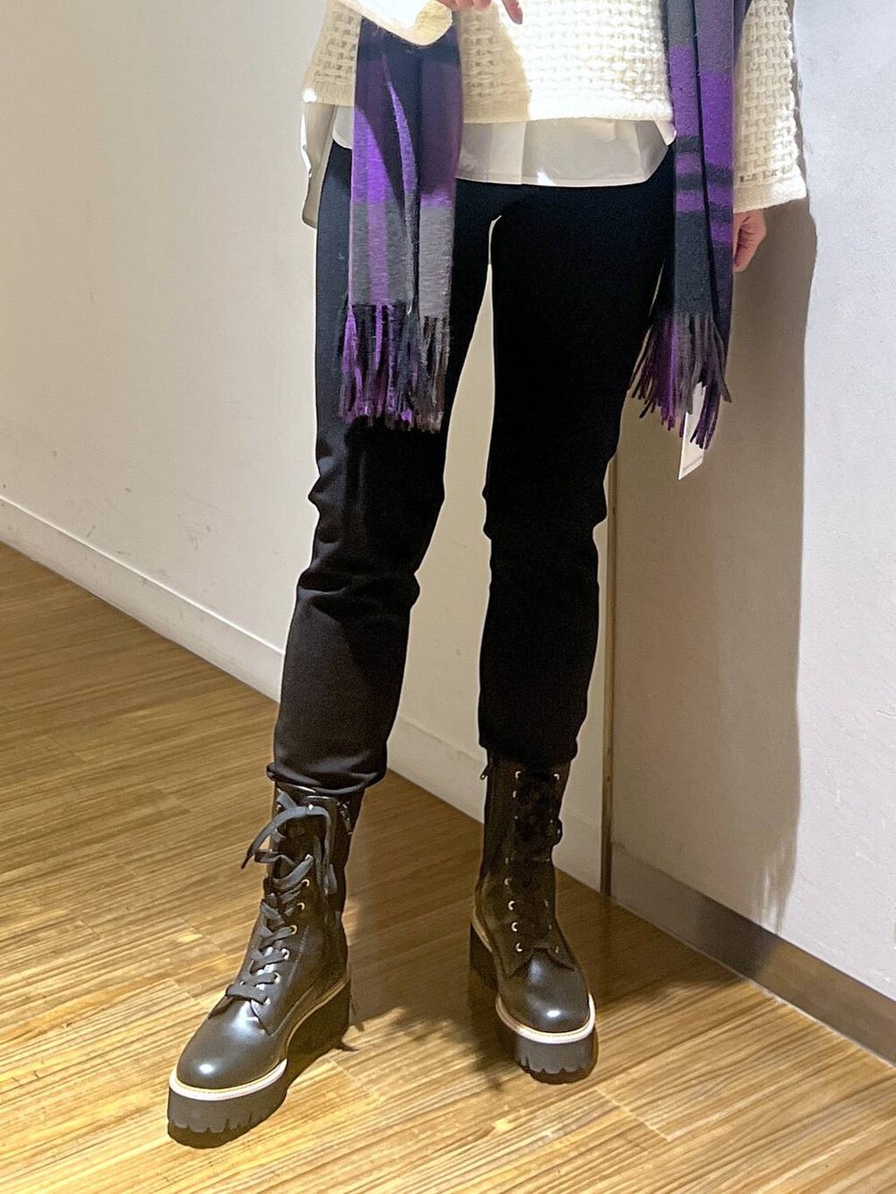 ホワイト系のシャツ/ブラウス、ホワイト系のニット/セーター、ブラック系のブーツを着用したレディースの秋コーディネートの4枚目の写真