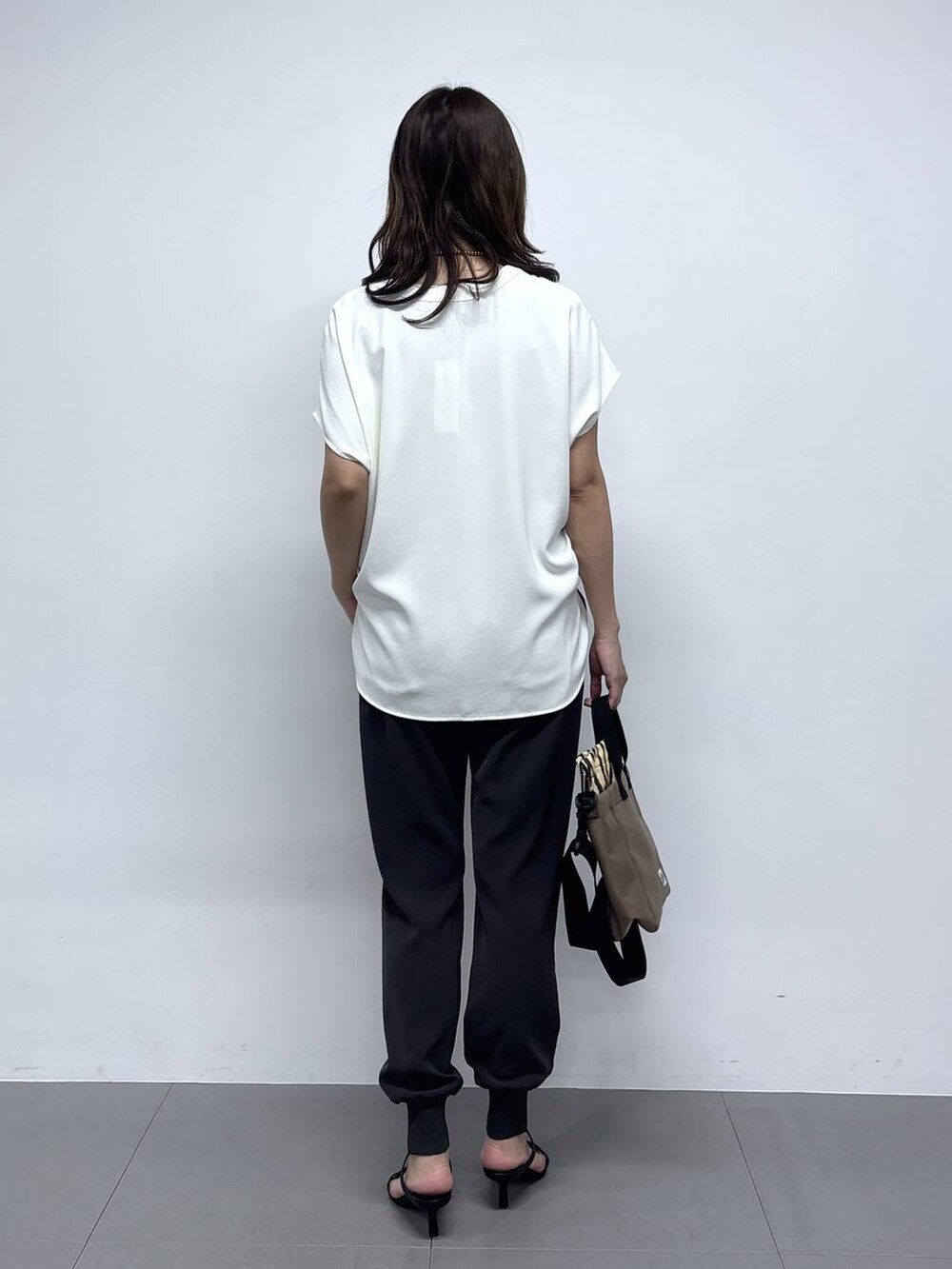 ホワイト系のシャツ/ブラウス、ブラック系のサンダル、グレー系のその他パンツを着用したレディースの春コーディネートの5枚目の写真