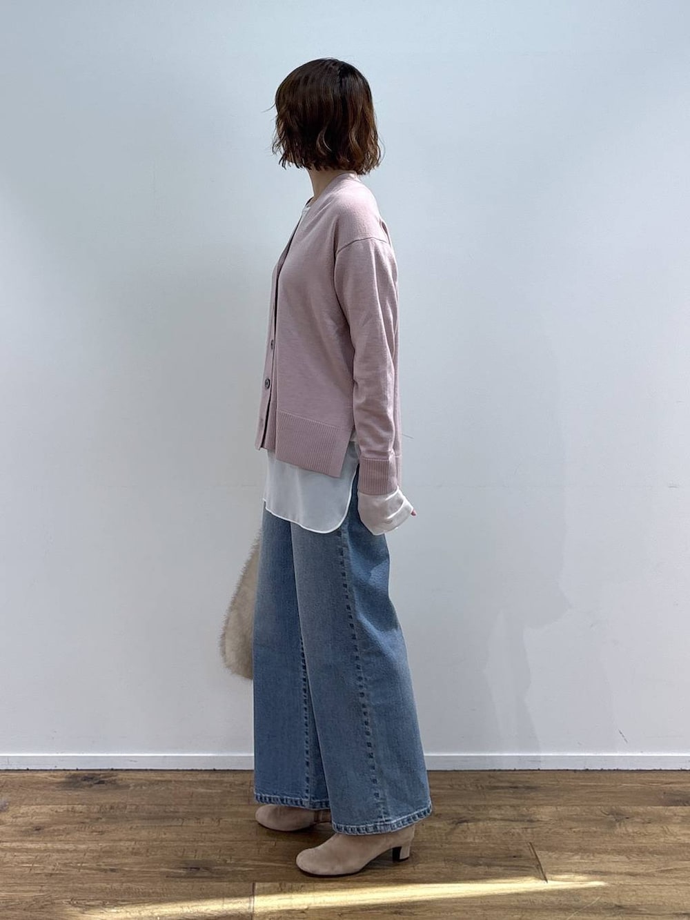 ベージュ系のショルダーバッグ、ブルー系のデニムパンツ、ホワイト系のTシャツ/カットソーを着用したレディースの秋コーディネートの3枚目の写真