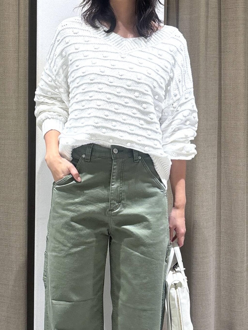 ホワイト系のニット/セーター、グリーン系のその他パンツ、ホワイト系のショルダーバッグを着用したレディースの冬コーディネートの4枚目の写真