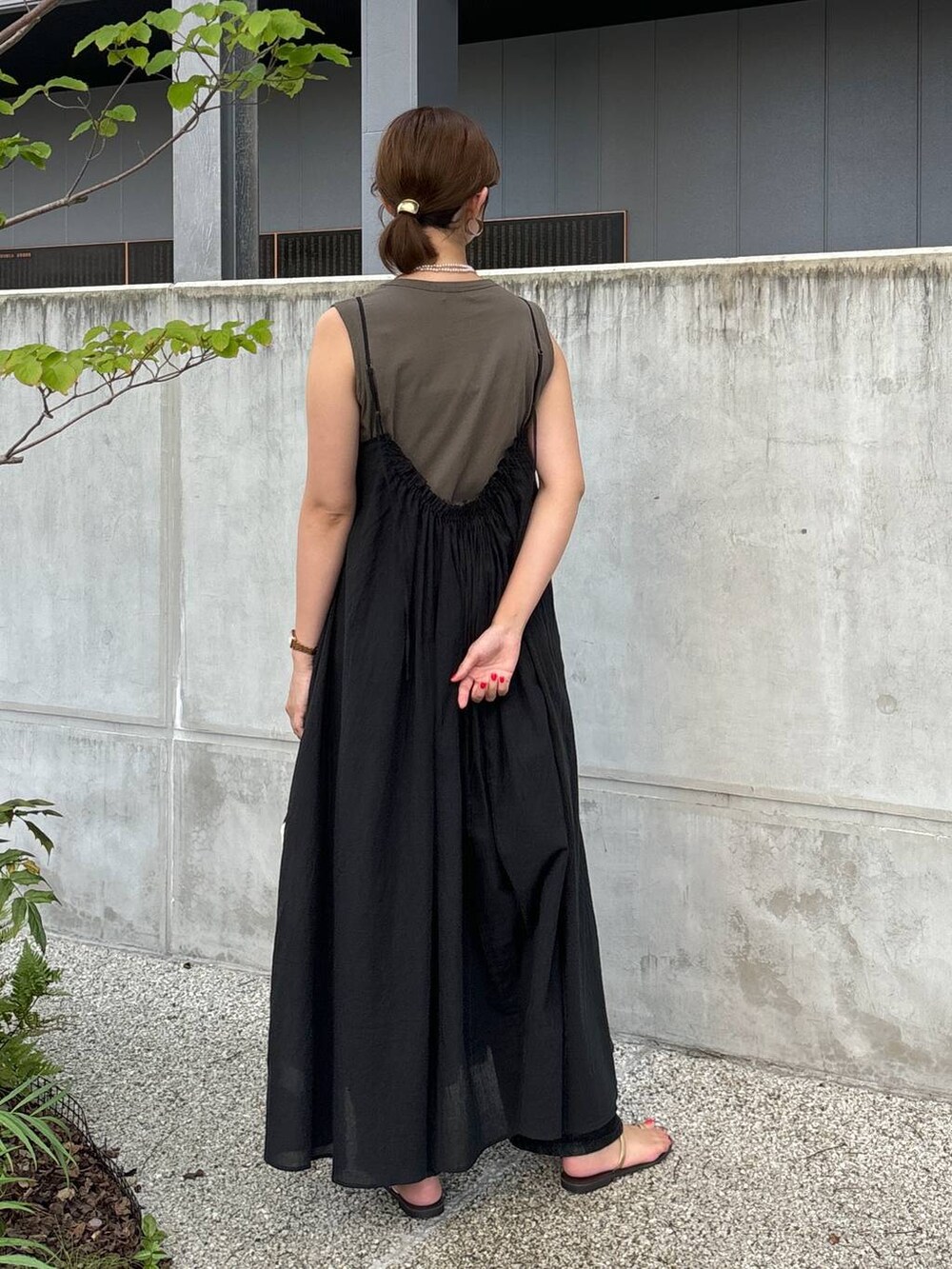 ブラック系のワンピース、ブラック系のデニムパンツ、ホワイト系のトートバッグを着用したレディースの夏コーディネートの4枚目の写真