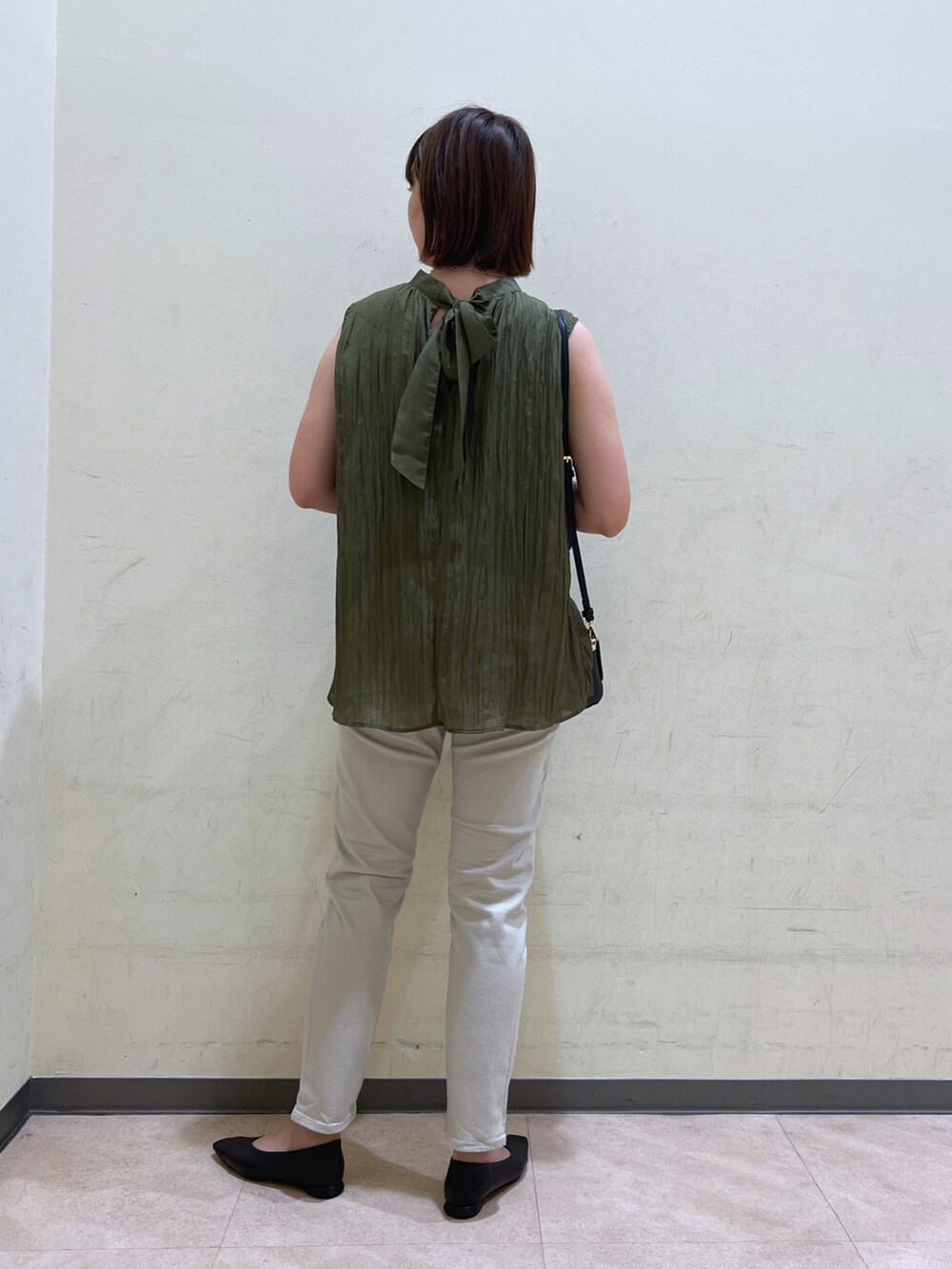 グリーン系のシャツ/ブラウス、グレー系のデニムパンツ、ブラック系のパンプスを着用したレディースの夏コーディネートの2枚目の写真