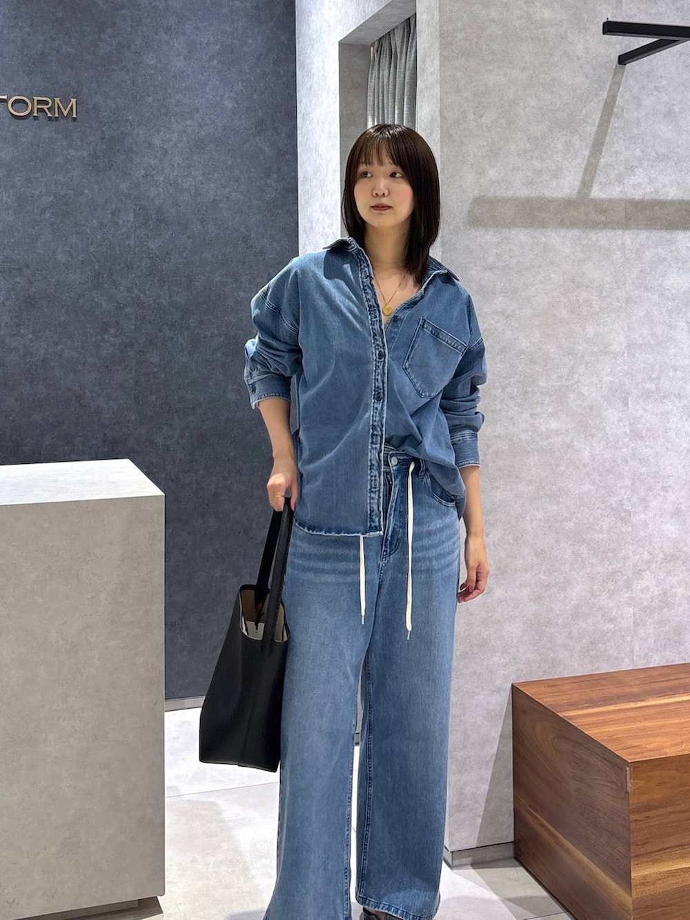 ブルー系のシャツ/ブラウス、ブルー系のデニムパンツ、ブラック系のローファーを着用したレディースの春コーディネートの2枚目の写真