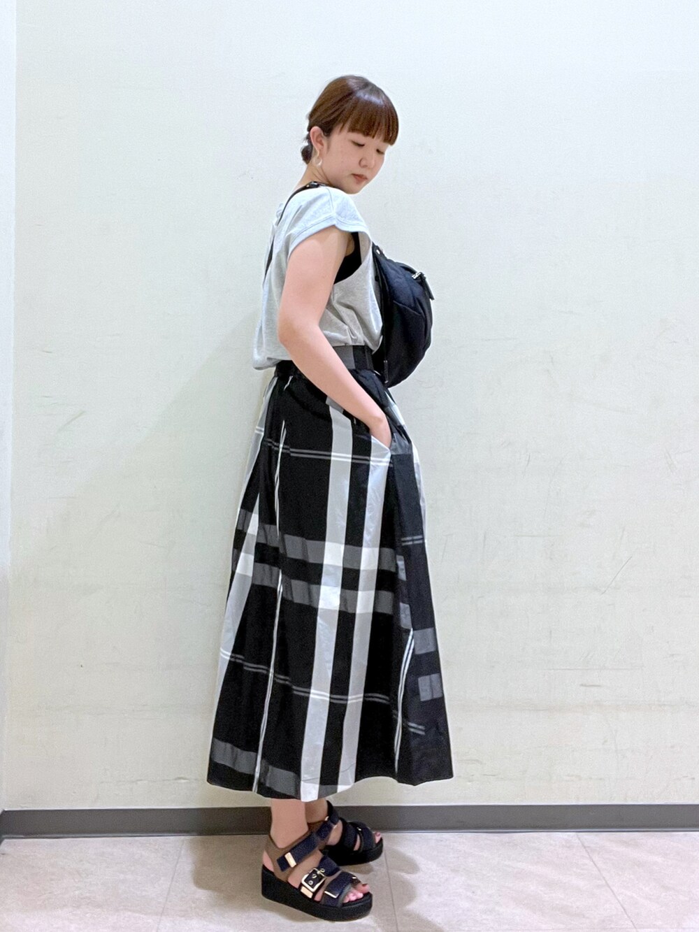 ブラック系のボディバッグ/ウエストポーチ、グレー系のTシャツ/カットソー、ブラック系のスカートを着用したレディースの夏コーディネートの3枚目の写真