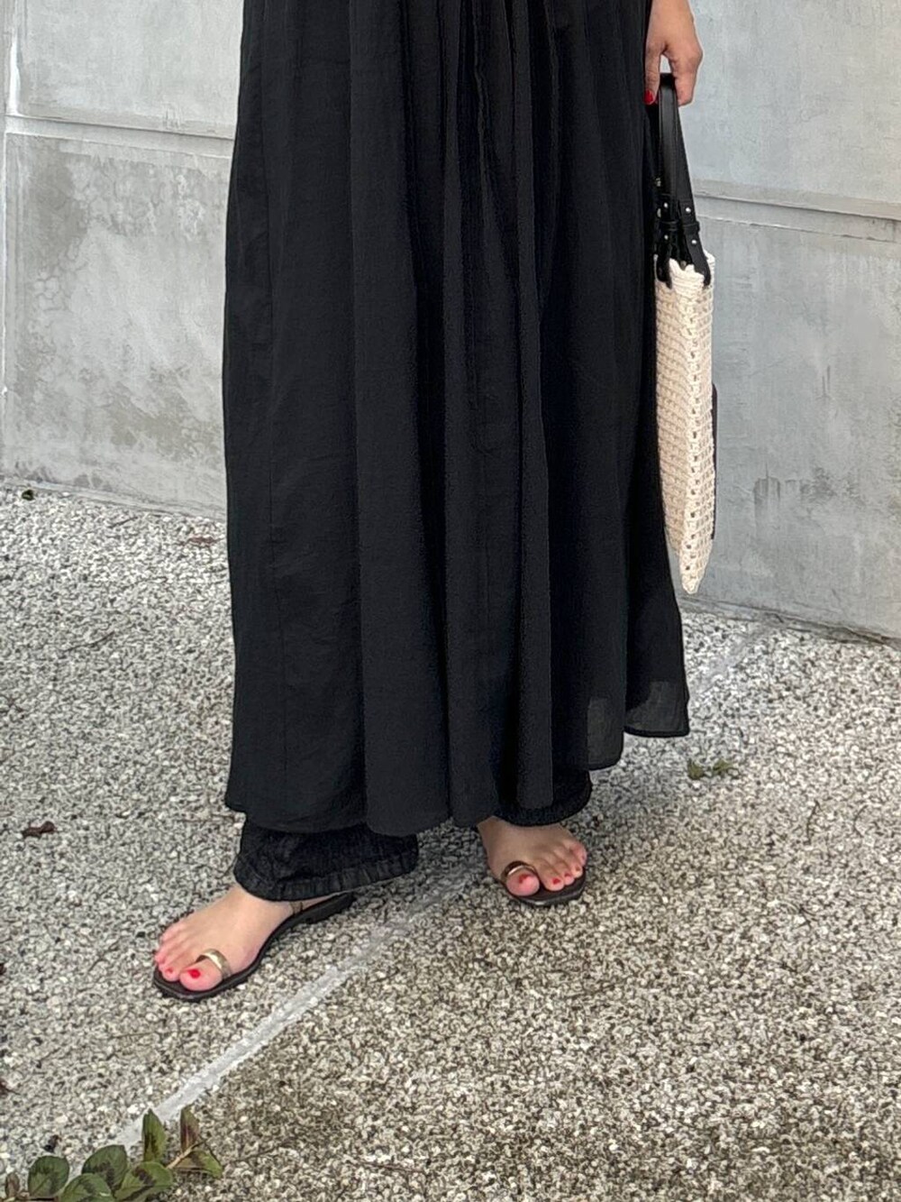 ブラック系のワンピース、ブラック系のデニムパンツ、ホワイト系のトートバッグを着用したレディースの夏コーディネートの5枚目の写真