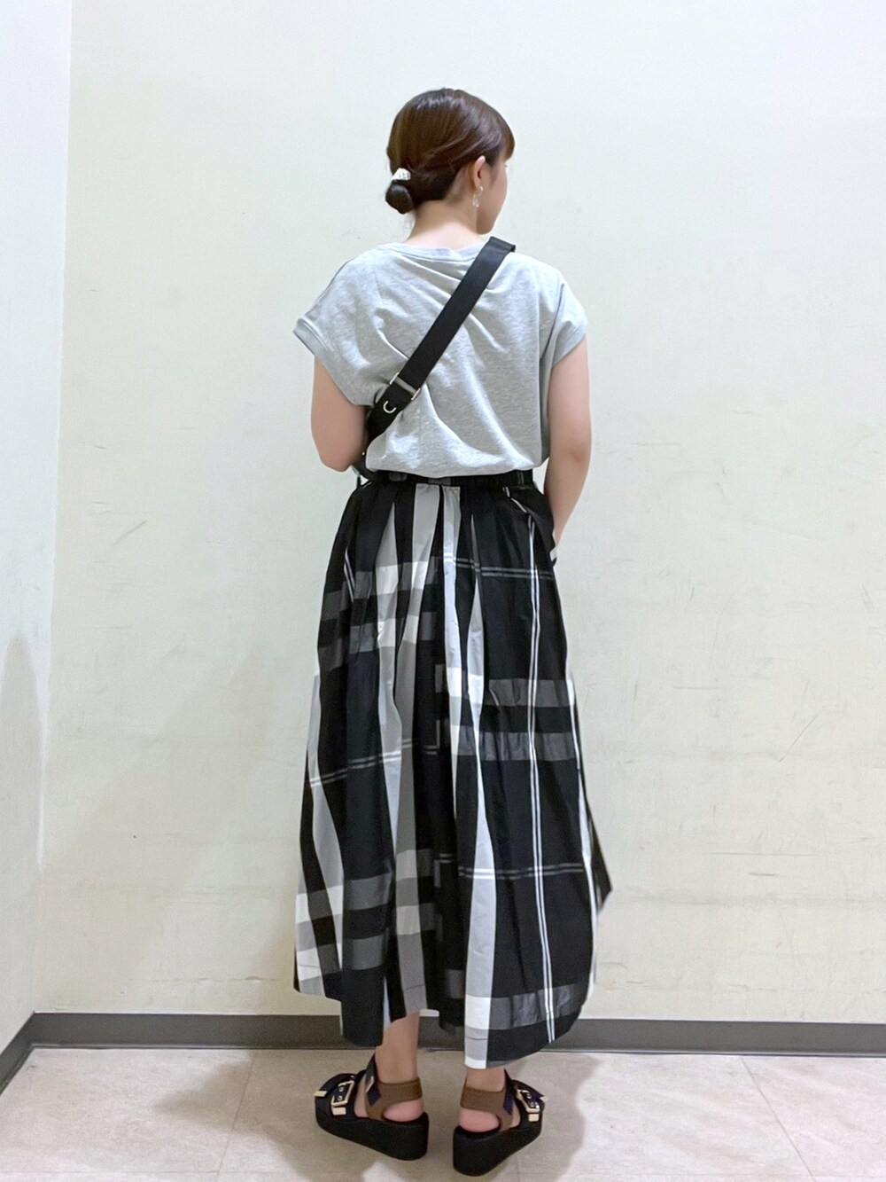 ブラック系のボディバッグ/ウエストポーチ、グレー系のTシャツ/カットソー、ブラック系のスカートを着用したレディースの夏コーディネートの4枚目の写真