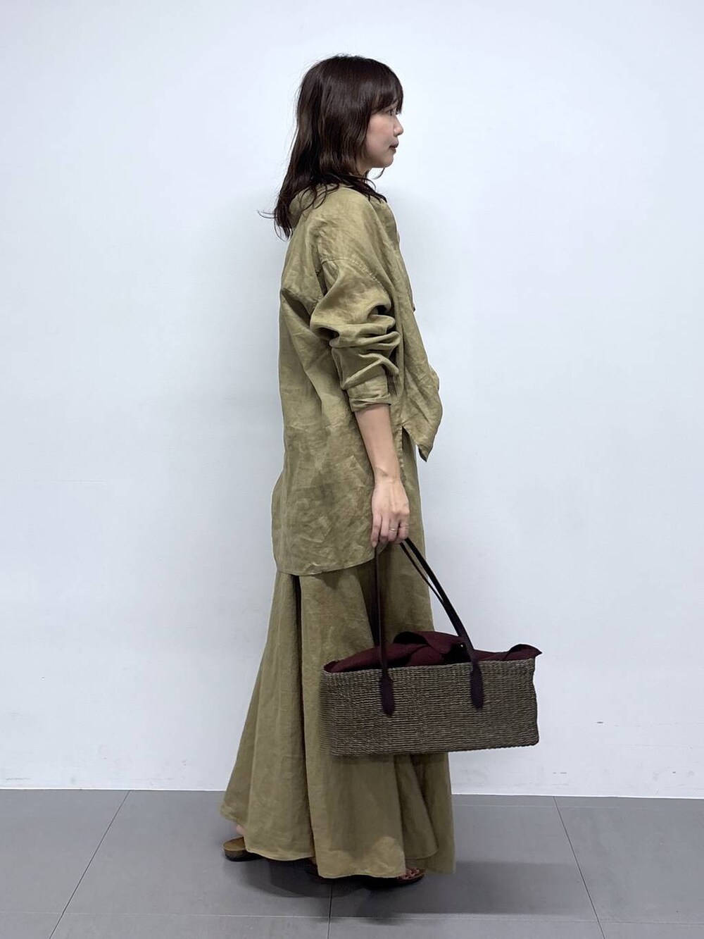 ベージュ系のシャツ/ブラウス、ベージュ系のスカート、ブラック系のサンダルを着用したレディースの春コーディネートの2枚目の写真