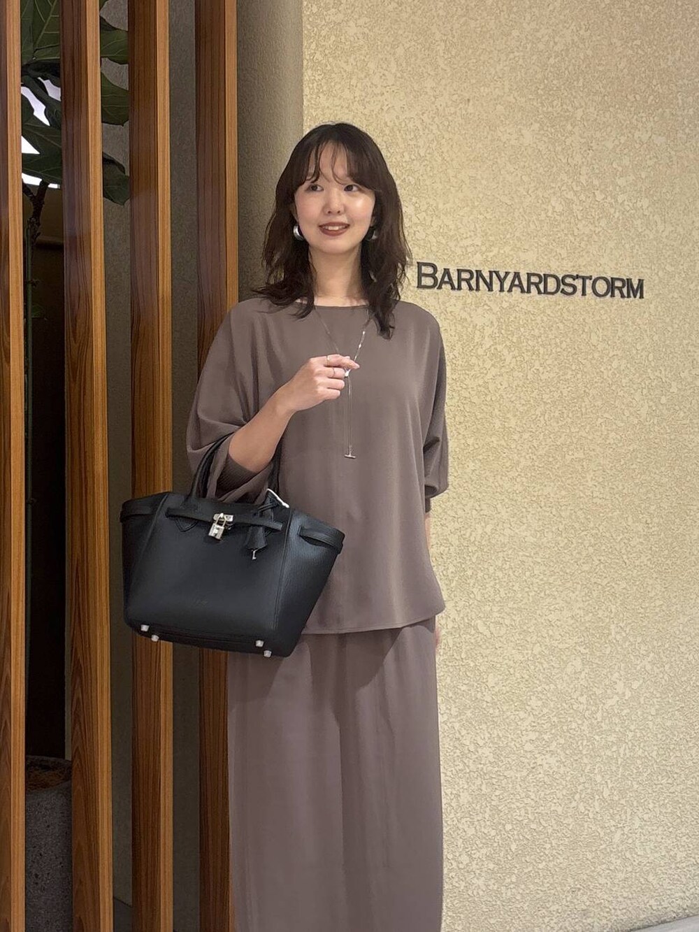 グリーン系のスカート、グリーン系のTシャツ/カットソー、ブラック系のハンドバッグを着用したレディースの冬コーディネートの3枚目の写真