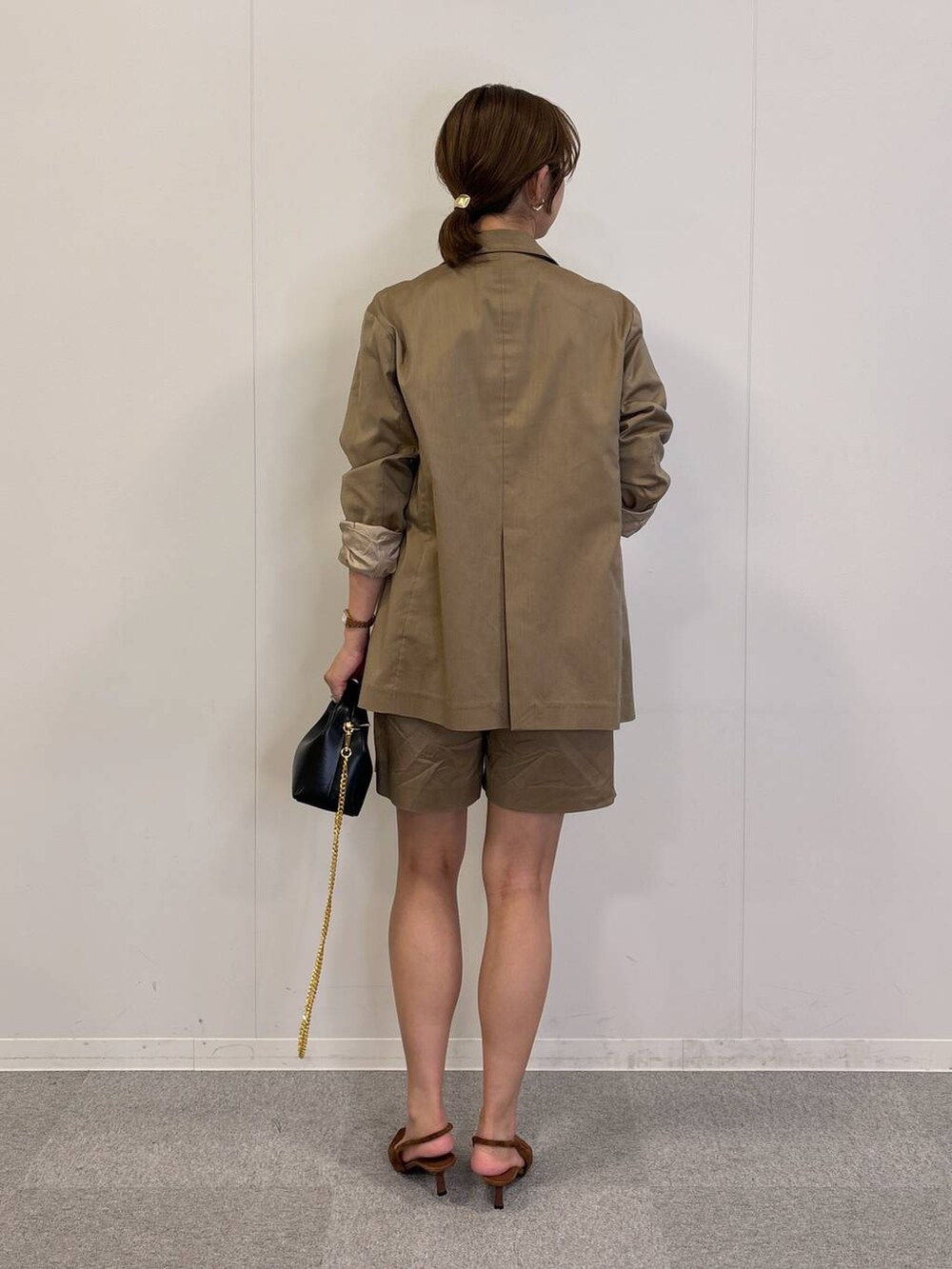 ブラック系のショルダーバッグ、ブラック系のTシャツ/カットソー、ベージュ系のテーラードジャケットを着用したレディースの秋コーディネートの5枚目の写真