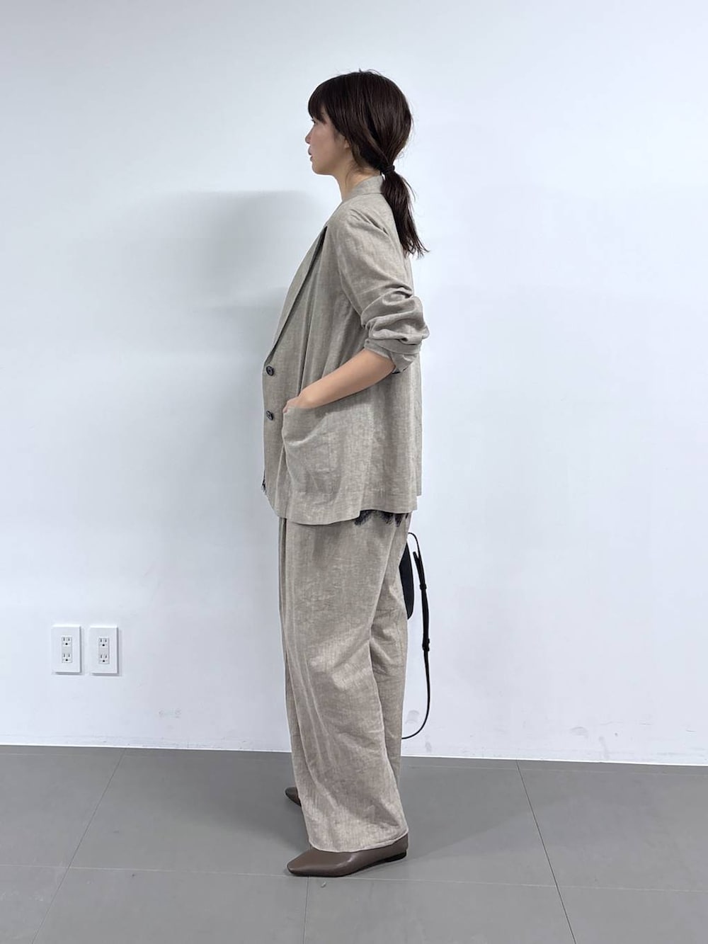 ベージュ系のその他パンツ、ベージュ系のテーラードジャケット、ブラック系のショルダーバッグを着用したレディースの春コーディネートの5枚目の写真