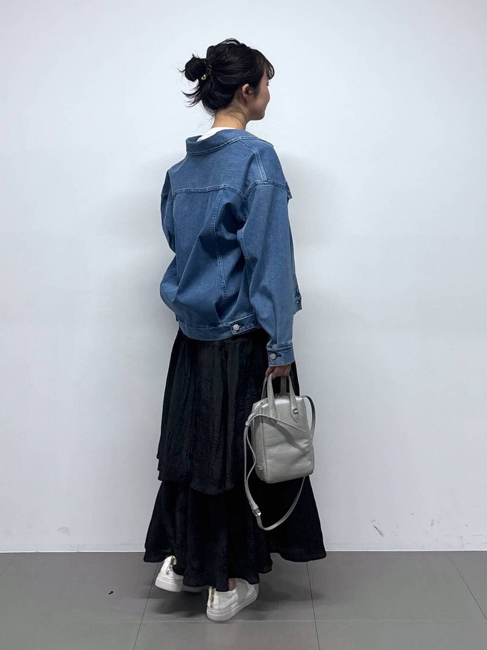 ブルー系のデニムジャケット、ホワイト系のTシャツ/カットソー、ブラック系のスカートを着用したレディースの冬コーディネートの3枚目の写真