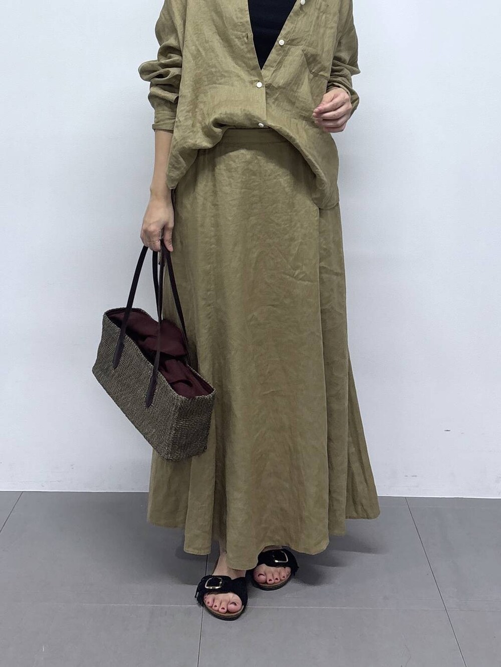 ベージュ系のシャツ/ブラウス、ベージュ系のスカート、ブラック系のサンダルを着用したレディースの春コーディネートの5枚目の写真