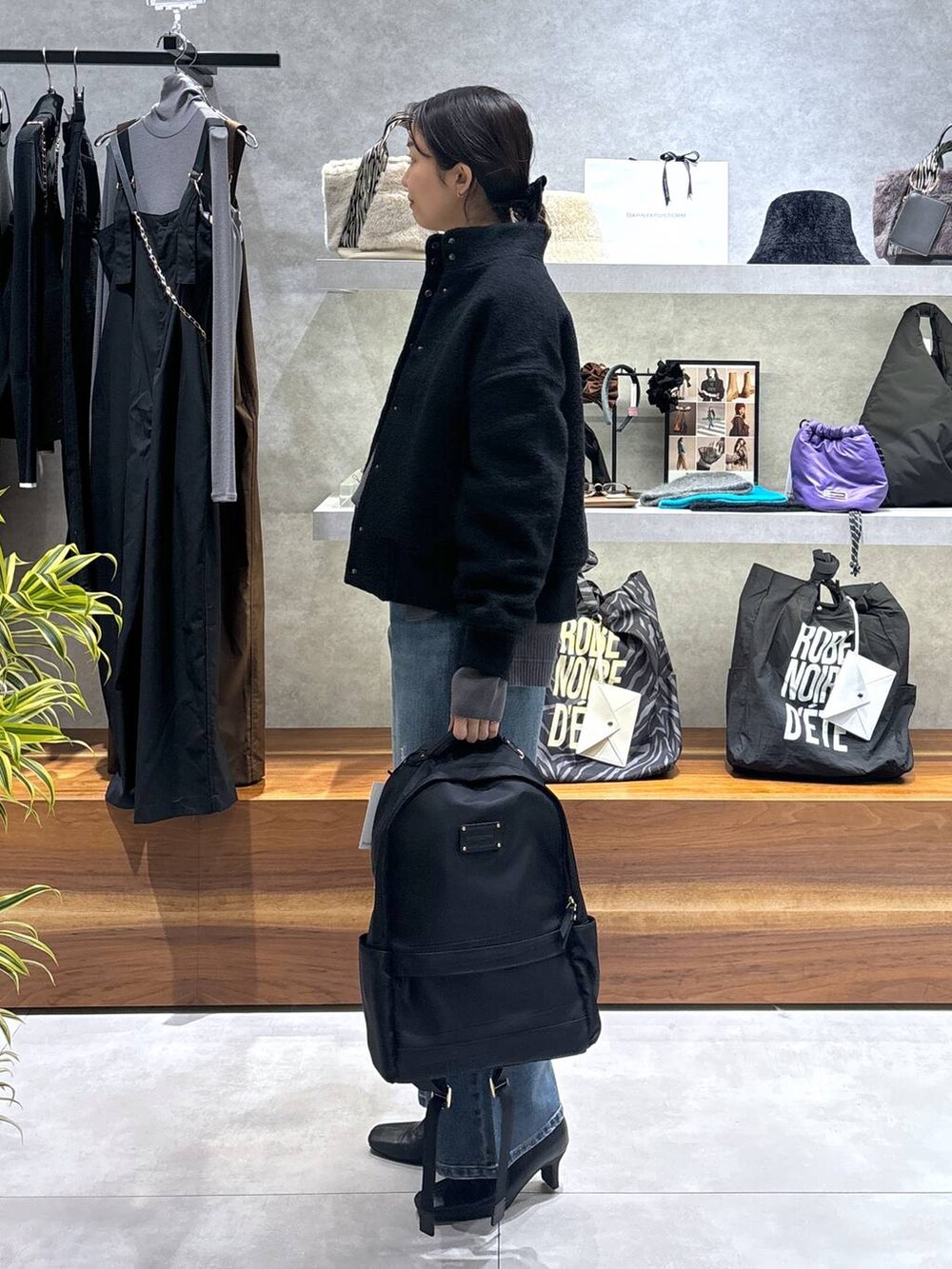 ブラック系のバックパック/リュック、ブラック系のブルゾン、ブルー系のデニムパンツを着用したレディースの冬コーディネートの5枚目の写真