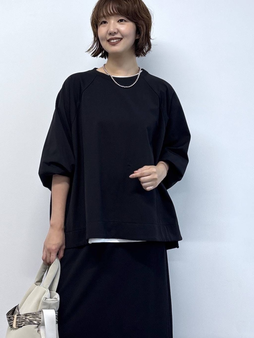 ホワイト系のTシャツ/カットソー、グレー系のトートバッグ、ブラック系のTシャツ/カットソーを着用したレディースの秋コーディネートの2枚目の写真