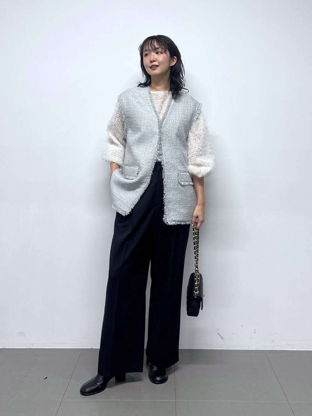 ホワイト系のシャツ/ブラウス、グレー系のその他アウター、ブラック系のショルダーバッグを着用したレディースの冬コーディネートの2枚目の写真