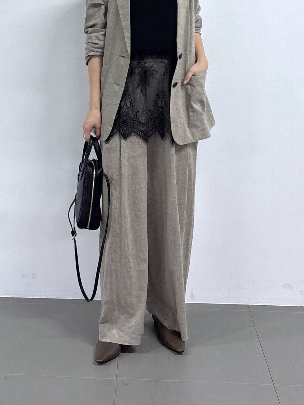 ベージュ系のその他パンツ、ベージュ系のテーラードジャケット、ブラック系のショルダーバッグを着用したレディースの春コーディネートの2枚目の写真