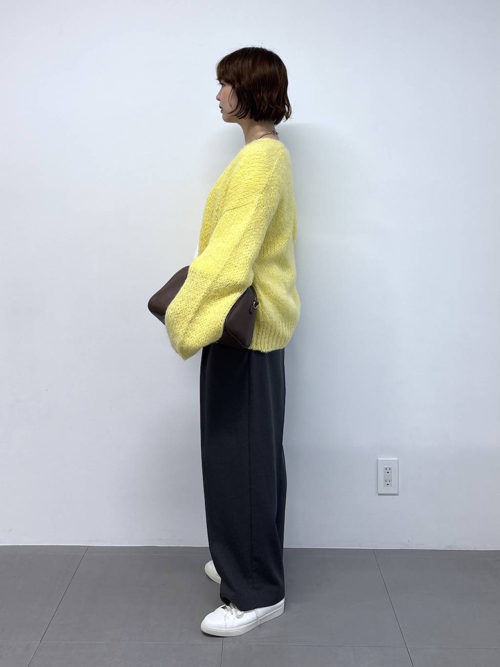 ホワイト系のTシャツ/カットソー、ブラウン系のボストンバッグ、イエロー系のカーディガン/ボレロを着用したレディースの秋コーディネートの2枚目の写真