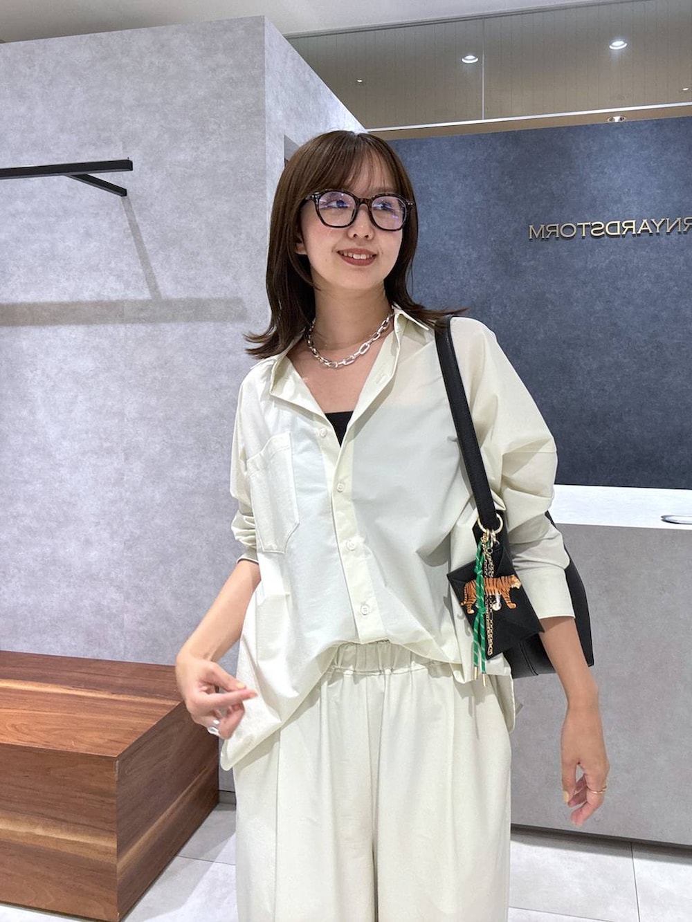 ブラック系のパンプス、ブラック系のトートバッグ、ホワイト系のシャツ/ブラウスを着用したレディースの夏コーディネートの2枚目の写真