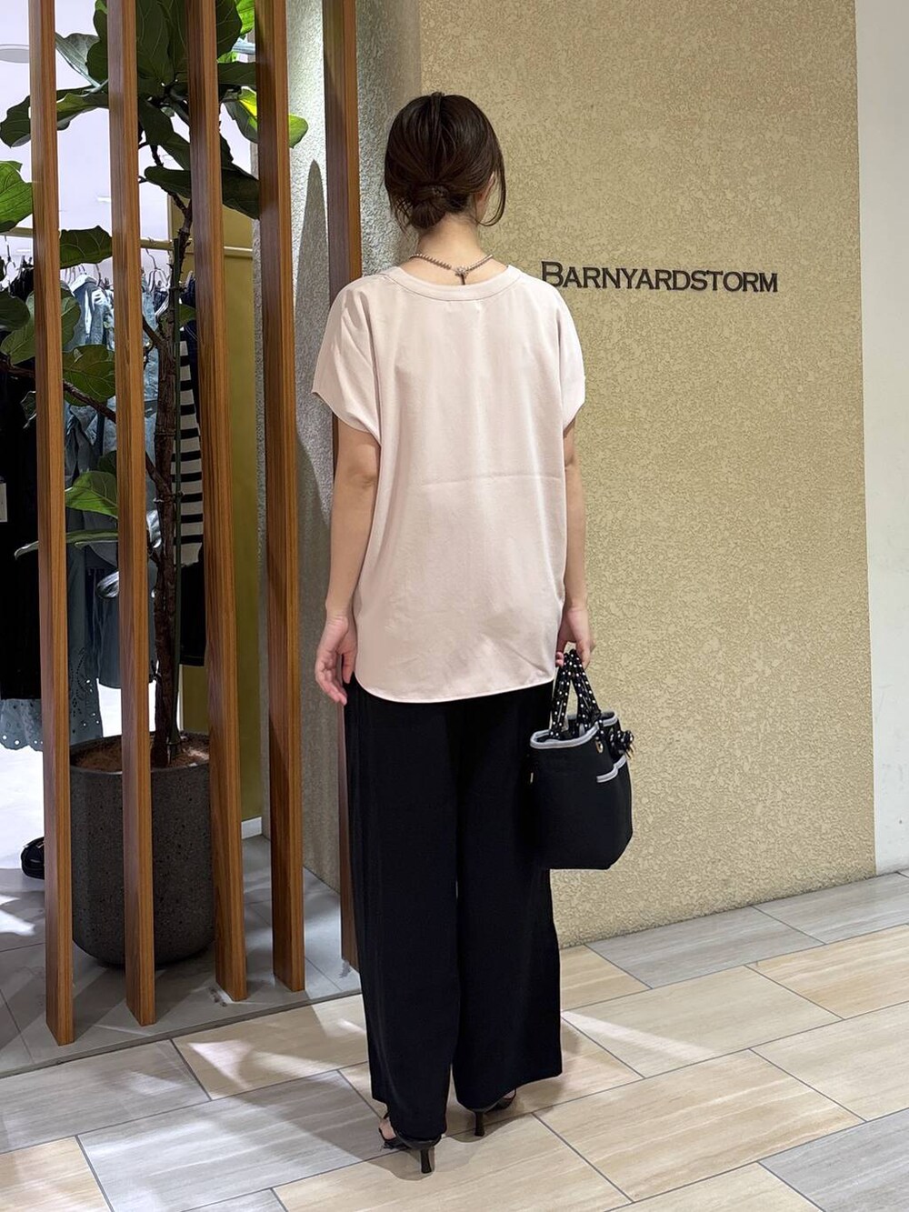 ブラック系のスラックス、ホワイト系のシャツ/ブラウス、ブラック系のトートバッグを着用したレディースの春コーディネートの4枚目の写真