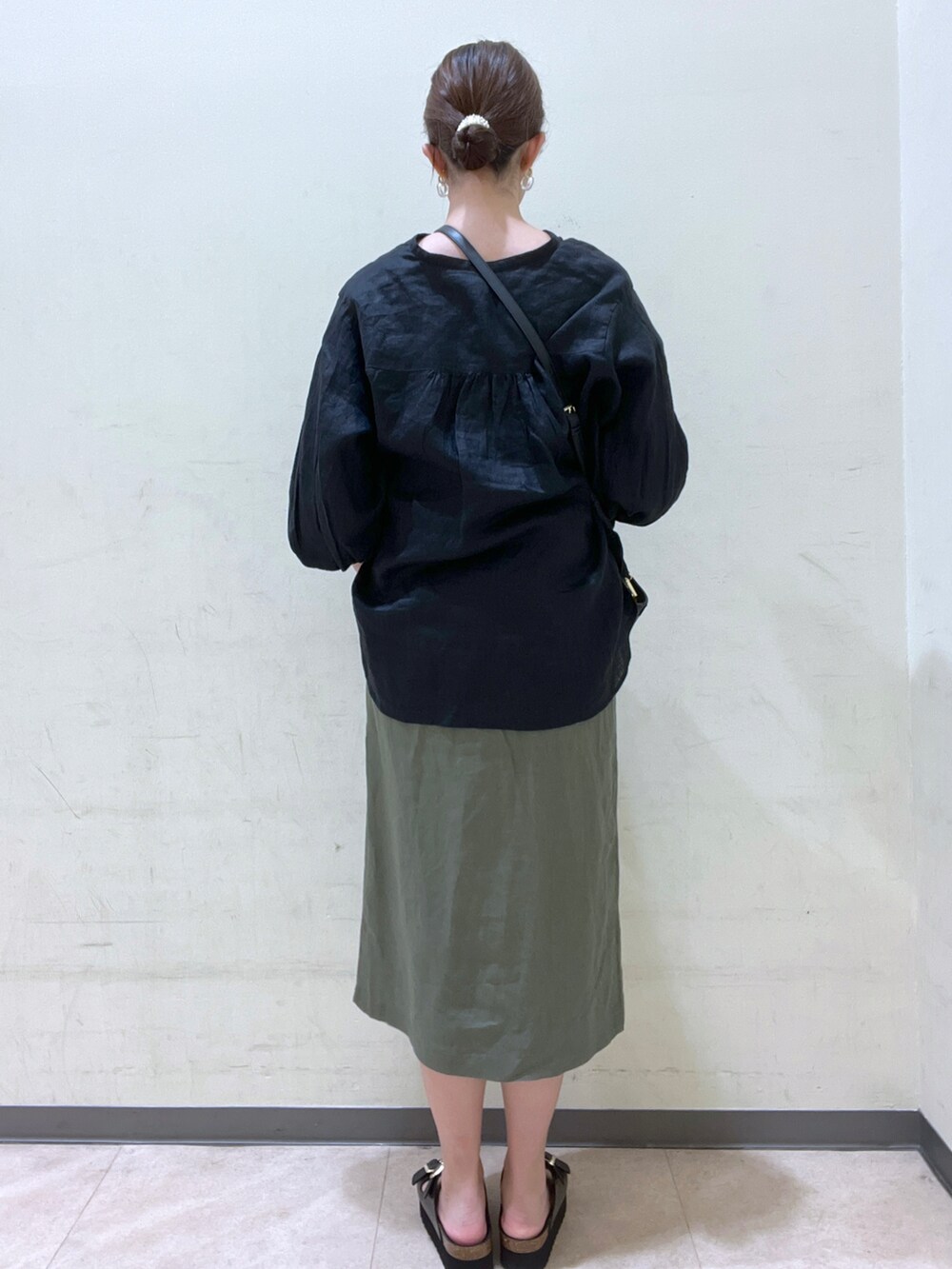 ブラック系のシャツ/ブラウス、ブラック系のバッグ、グリーン系のスカートを着用したレディースの夏コーディネートの2枚目の写真