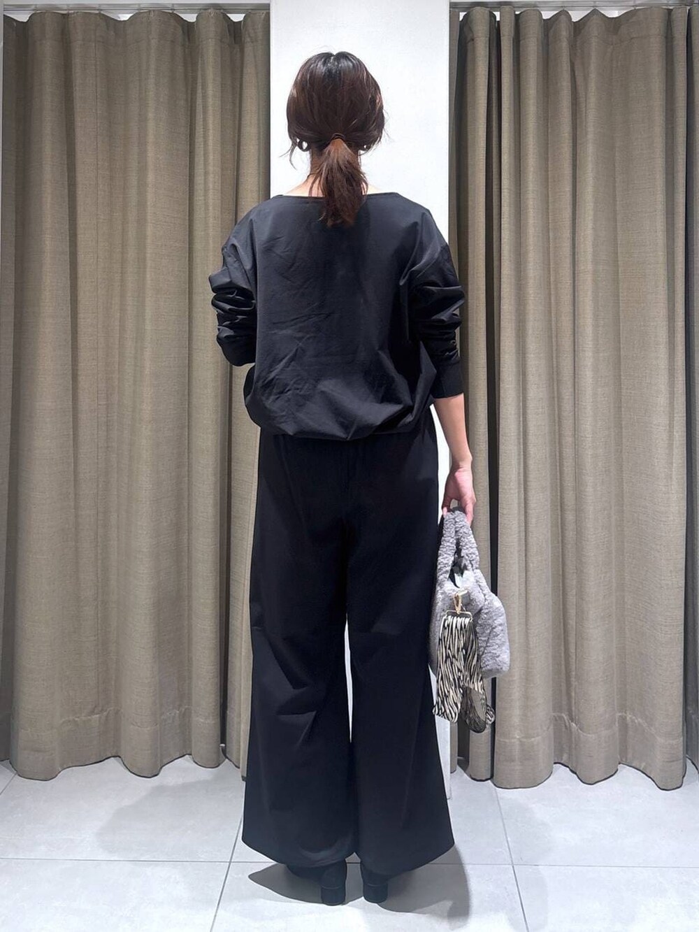 ブラック系のパンプス、グレー系のトートバッグ、ブラック系のTシャツ/カットソーを着用したレディースの秋コーディネートの4枚目の写真