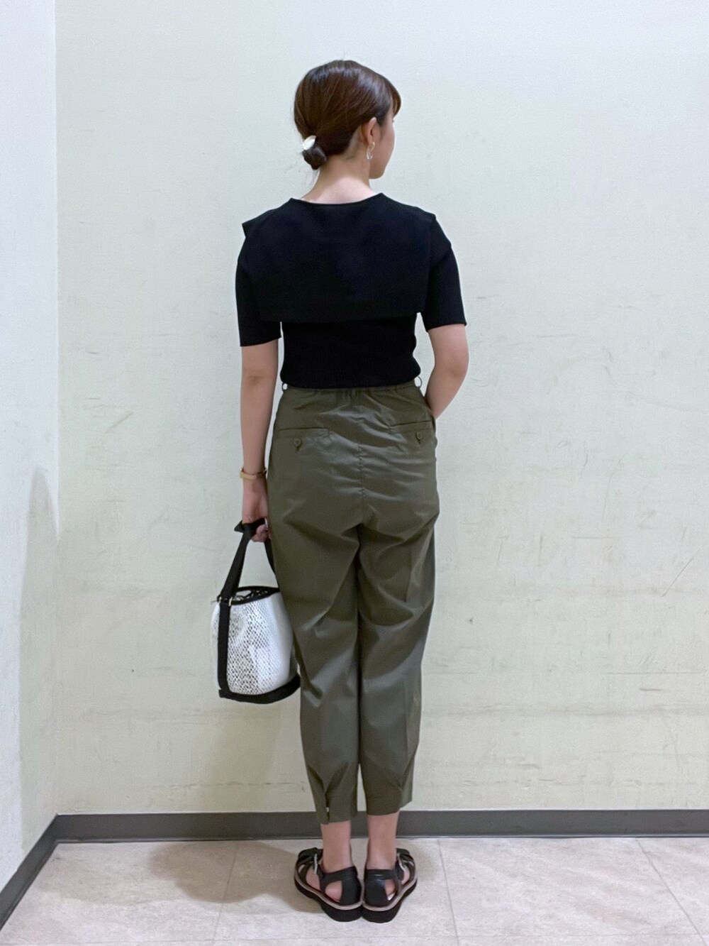 ブラック系のニット/セーター、グリーン系のその他パンツ、ホワイト系のバッグを着用したレディースの夏コーディネートの4枚目の写真
