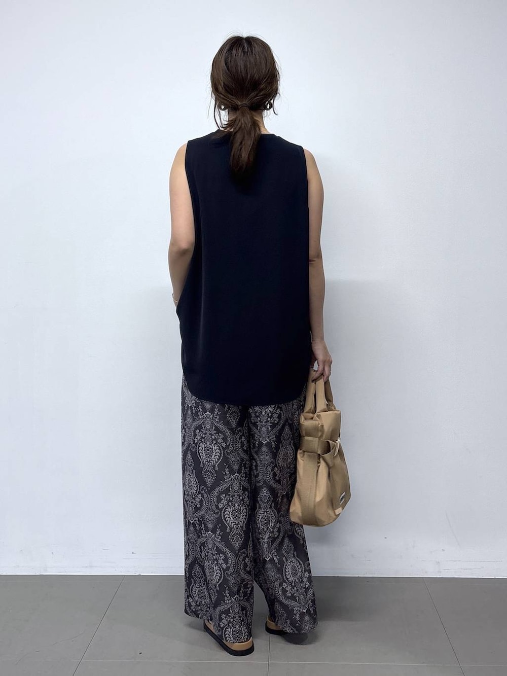 ブラウン系のショルダーバッグ、グレー系のその他パンツ、ブラウン系のサンダルを着用したレディースの春コーディネートの4枚目の写真