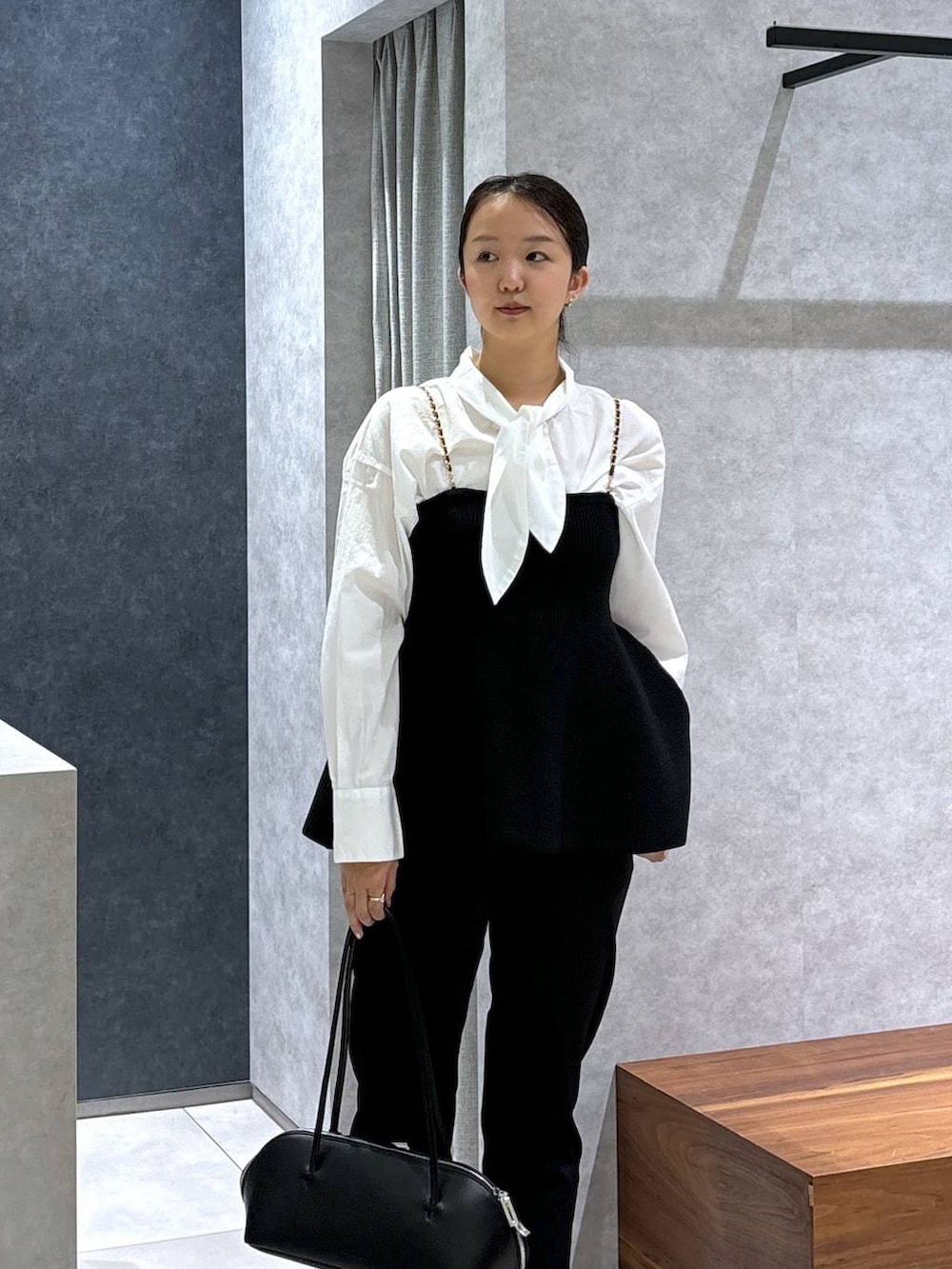 ブラック系のトートバッグ、ホワイト系のシャツ/ブラウス、ブラック系のその他パンツを着用したレディースの冬コーディネートの2枚目の写真