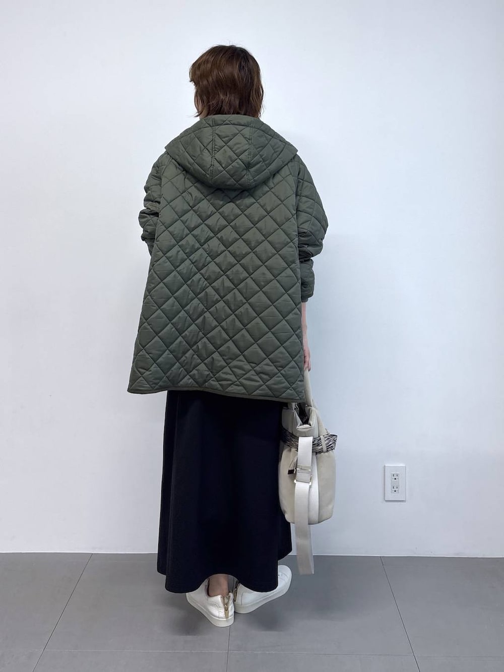 ホワイト系のTシャツ/カットソー、グレー系のトートバッグ、ブラック系のスカートを着用したレディースの秋コーディネートの5枚目の写真