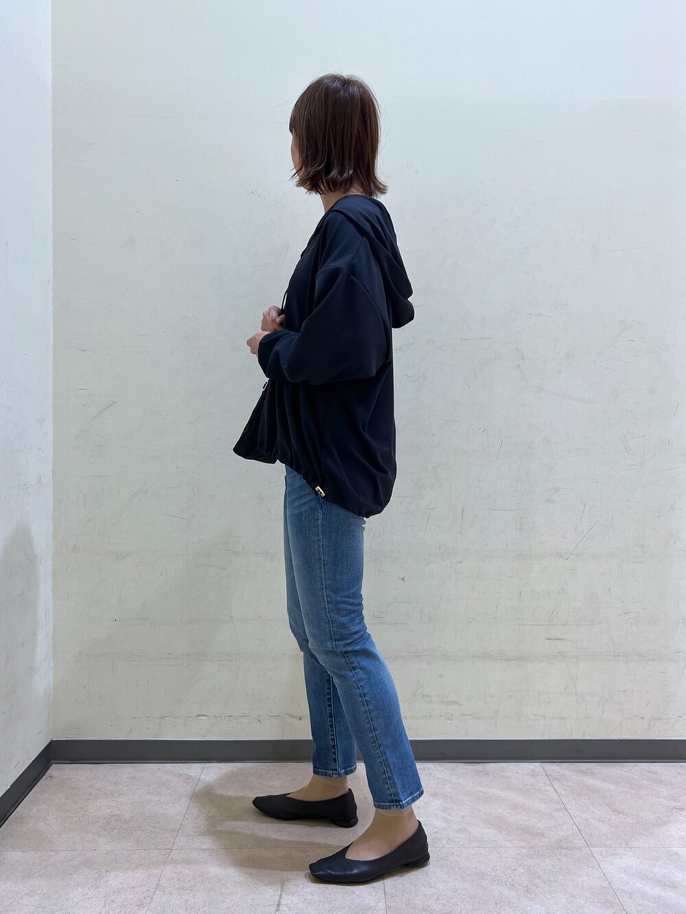 ブルー系のデニムパンツを着用したレディースの秋コーディネートの2枚目の写真