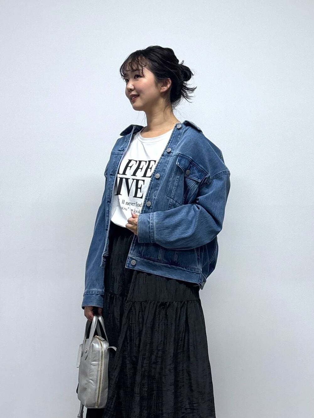 ブルー系のデニムジャケット、ホワイト系のTシャツ/カットソー、ブラック系のスカートを着用したレディースの冬コーディネートの2枚目の写真