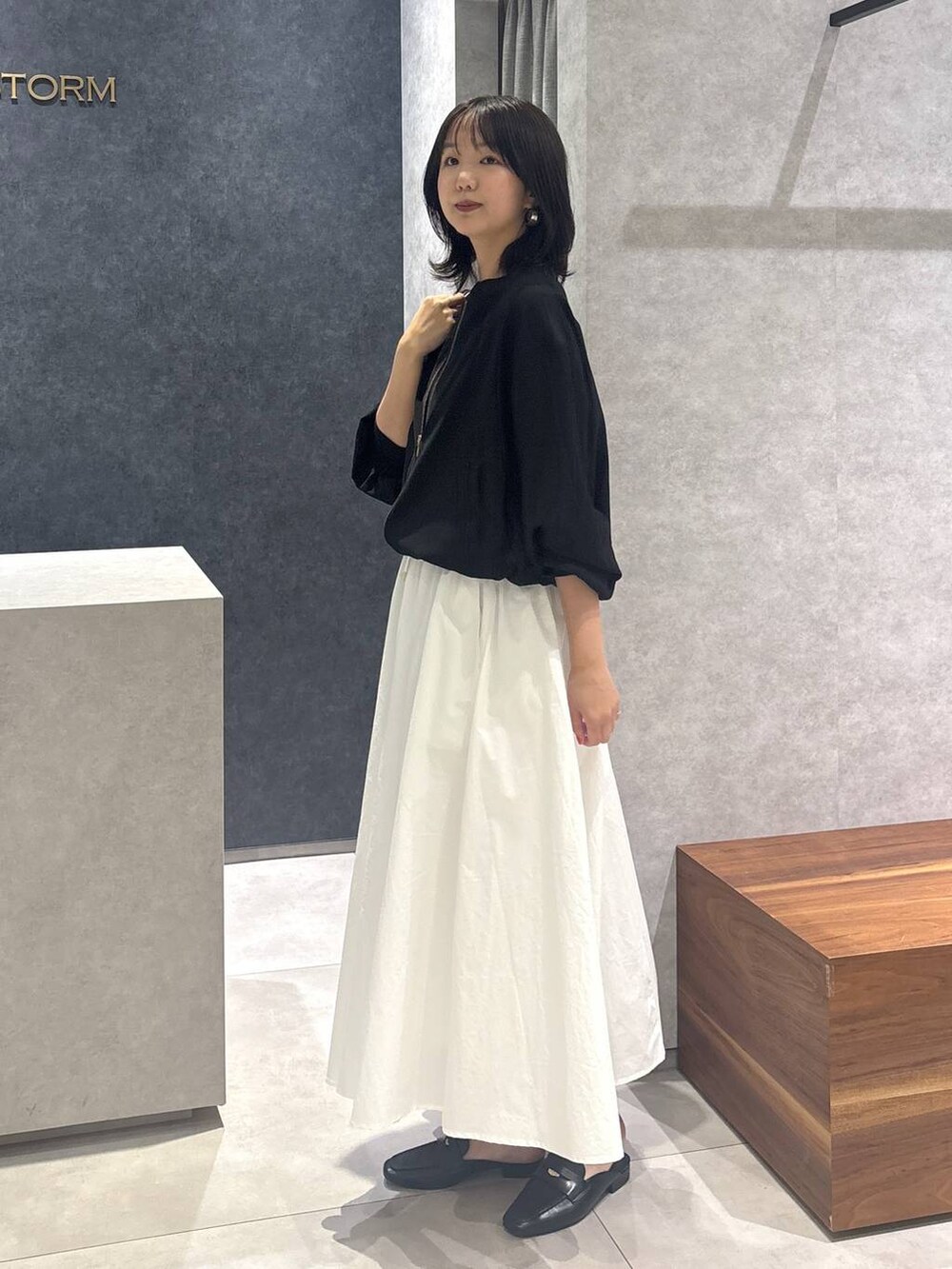 ホワイト系のスカート、ブラック系のローファー、ブラック系のボストンバッグを着用したレディースの春コーディネートの4枚目の写真