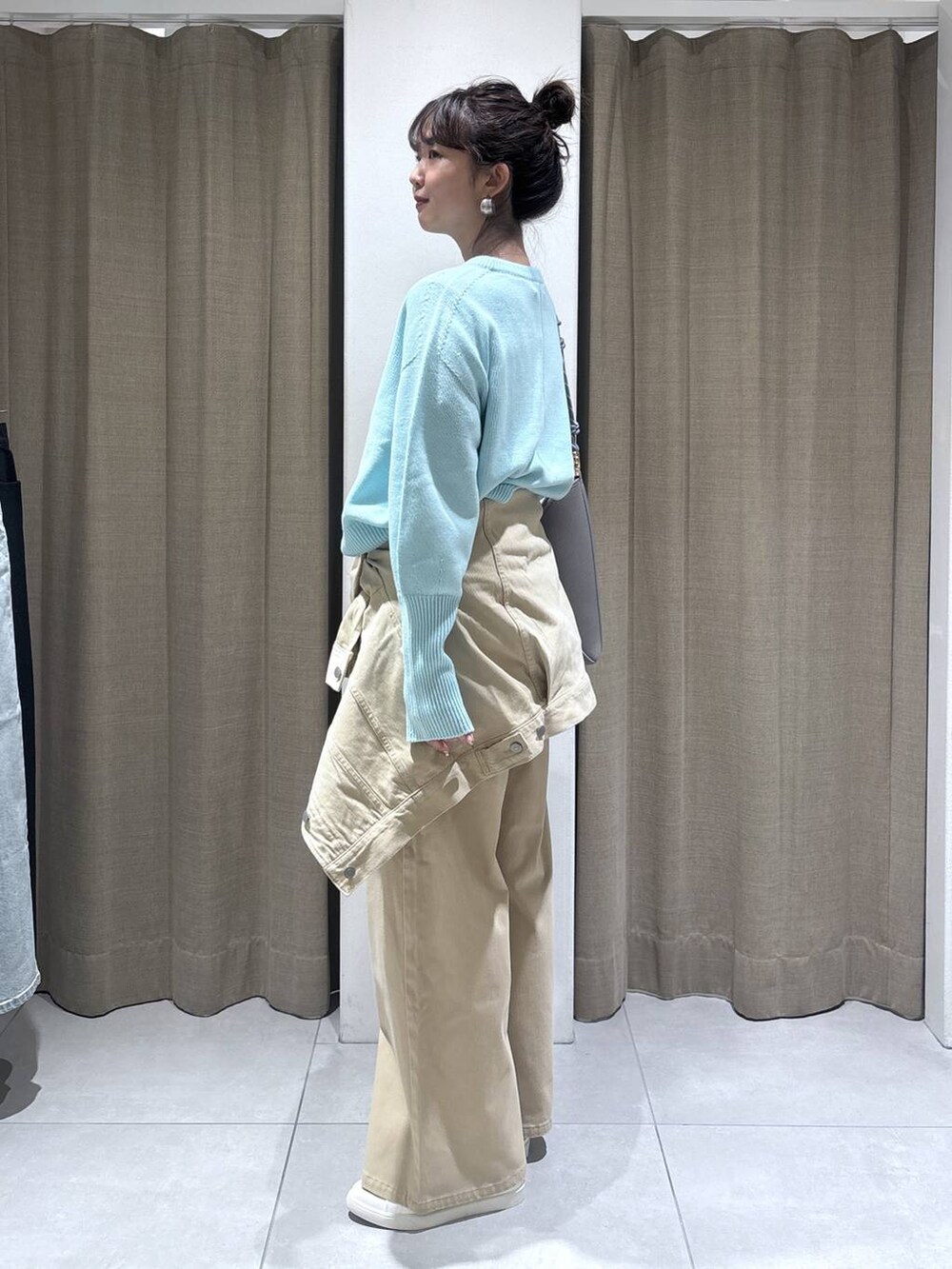 ブルー系のニット/セーター、ベージュ系のデニムパンツ、ベージュ系のデニムジャケットを着用したレディースの冬コーディネートの5枚目の写真