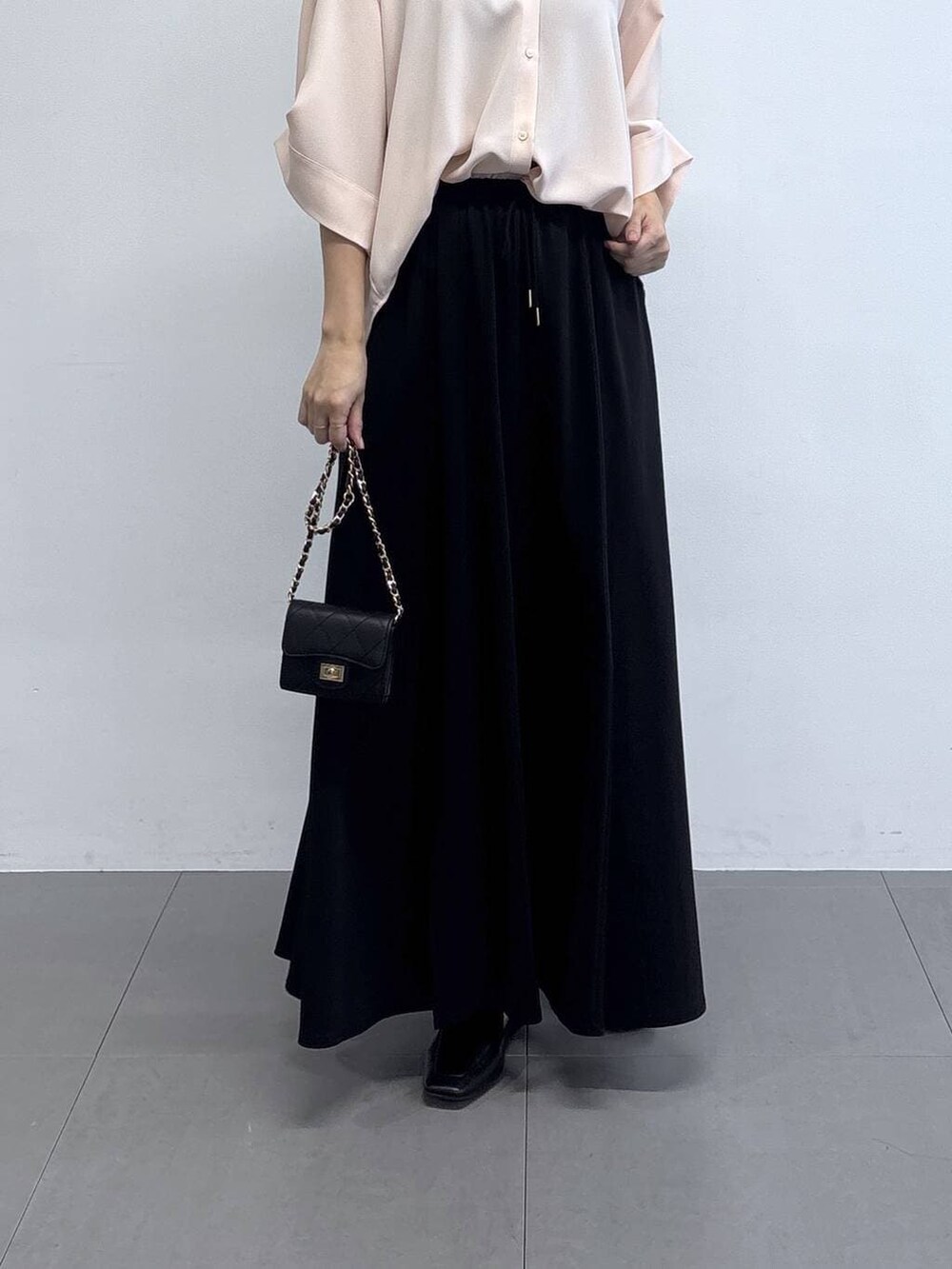 ピンク系のシャツ/ブラウス、ブラック系のローファー、ブラック系のショルダーバッグを着用したレディースの春コーディネートの3枚目の写真