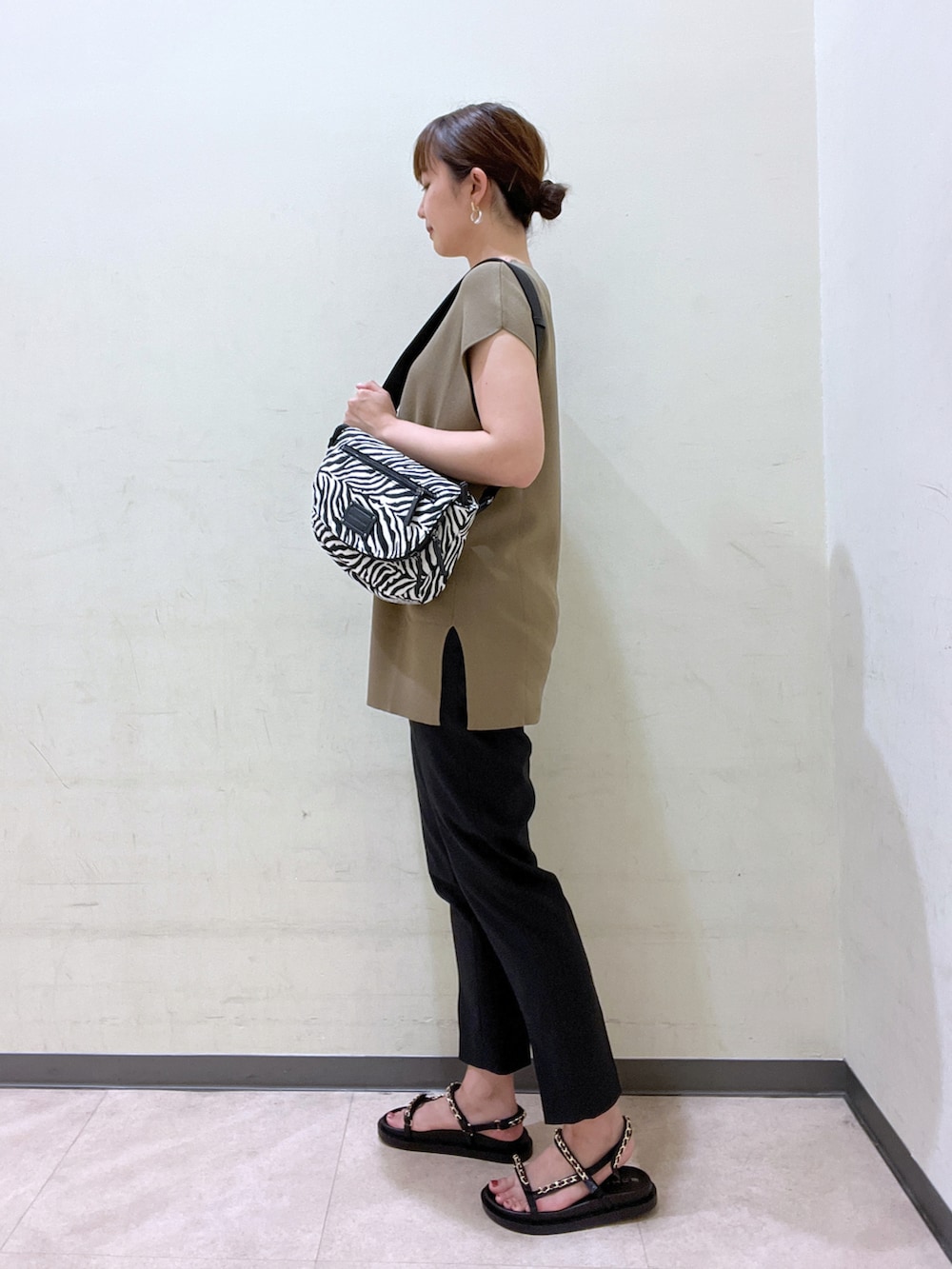 グリーン系のベスト、ブラック系のその他パンツ、ブラック系のシューズを着用したレディースの夏コーディネートの2枚目の写真