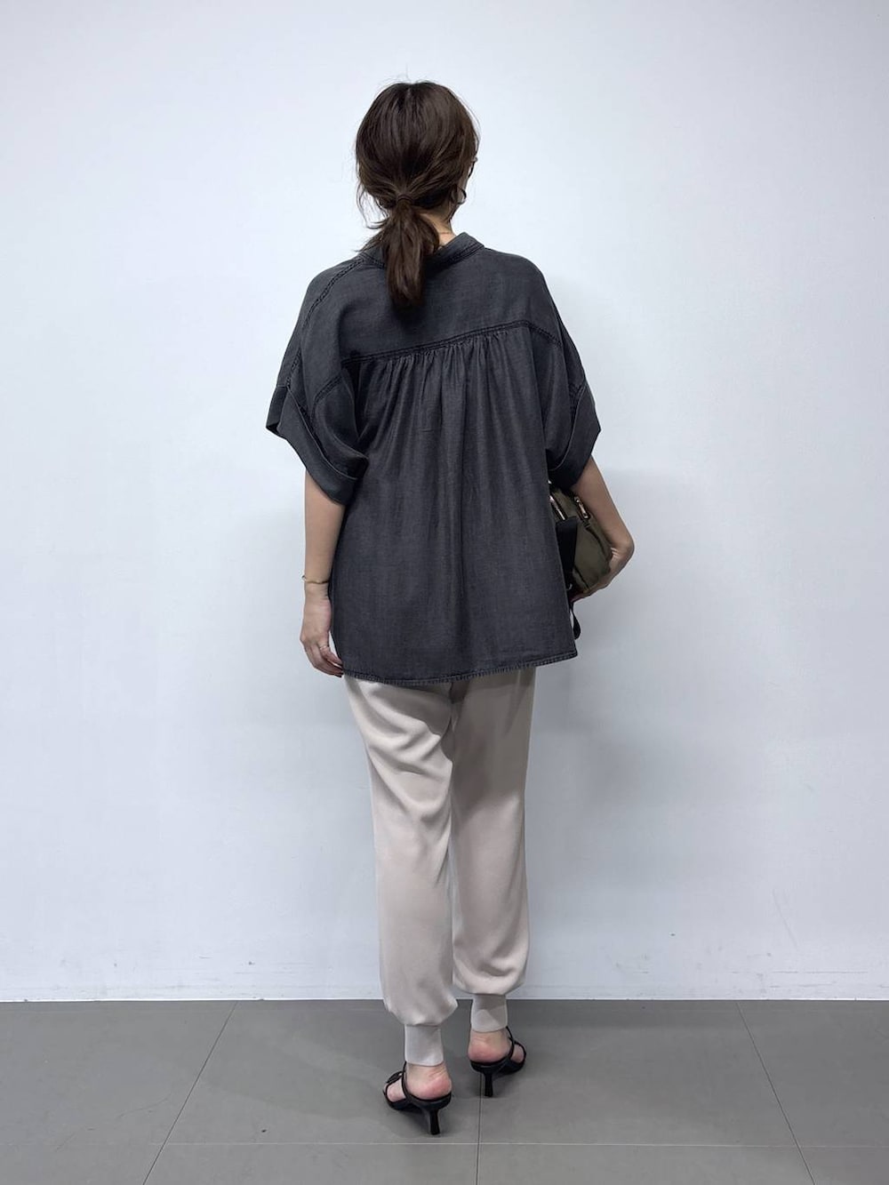ブラック系のシャツ/ブラウス、ブラウン系のショルダーバッグ、ベージュ系のその他パンツを着用したレディースの春コーディネートの4枚目の写真