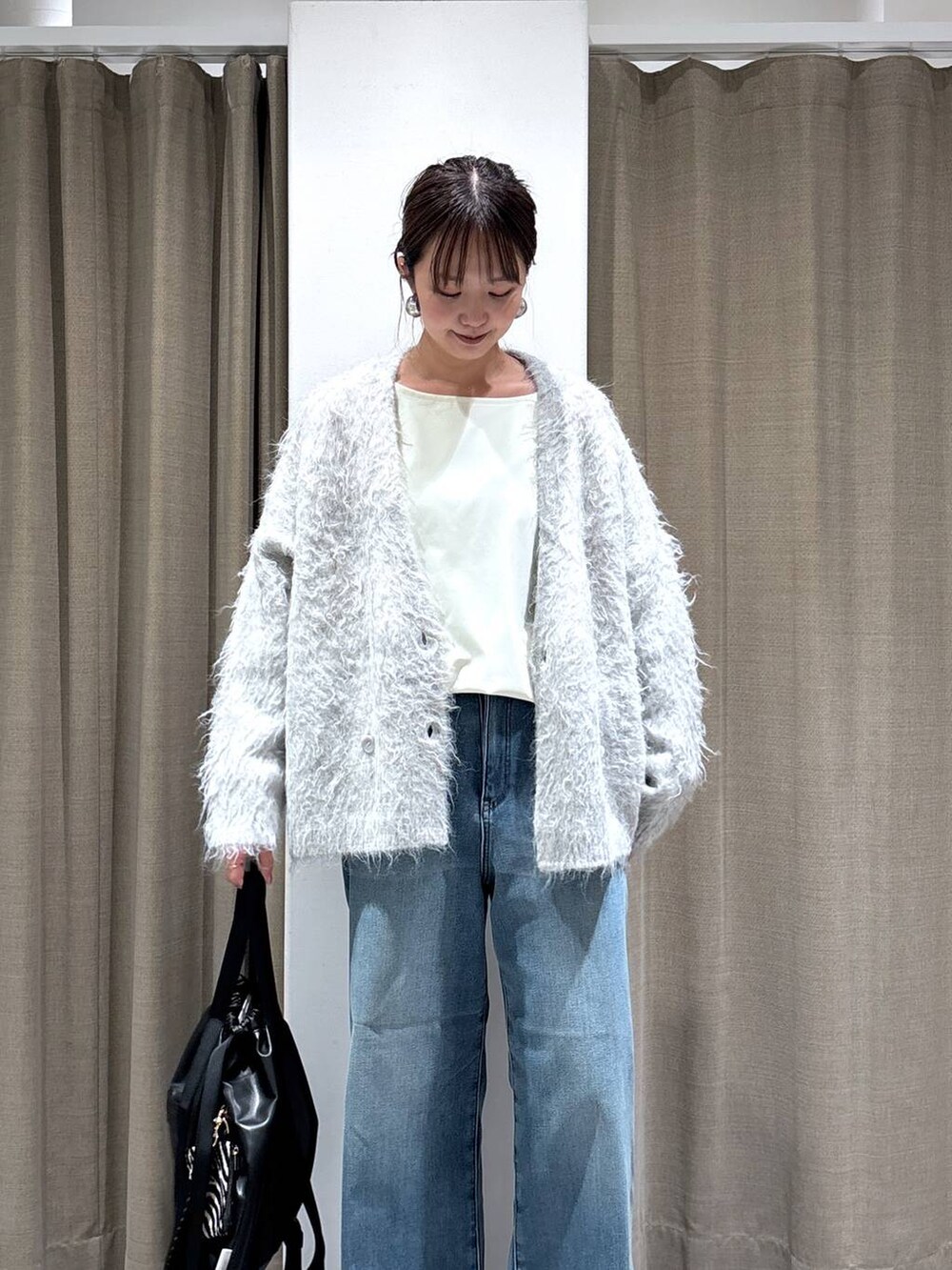 ブラック系のバックパック/リュック、ブルー系のデニムパンツ、イエロー系のブーツを着用したレディースの秋コーディネートの3枚目の写真