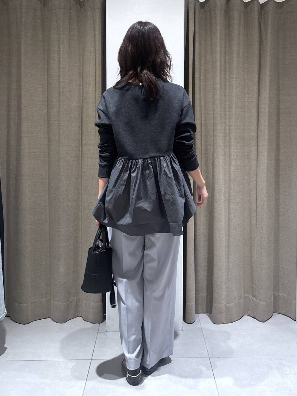 グレー系のその他パンツ、ブラック系のハンドバッグ、グレー系のTシャツ/カットソーを着用したレディースの冬コーディネートの4枚目の写真